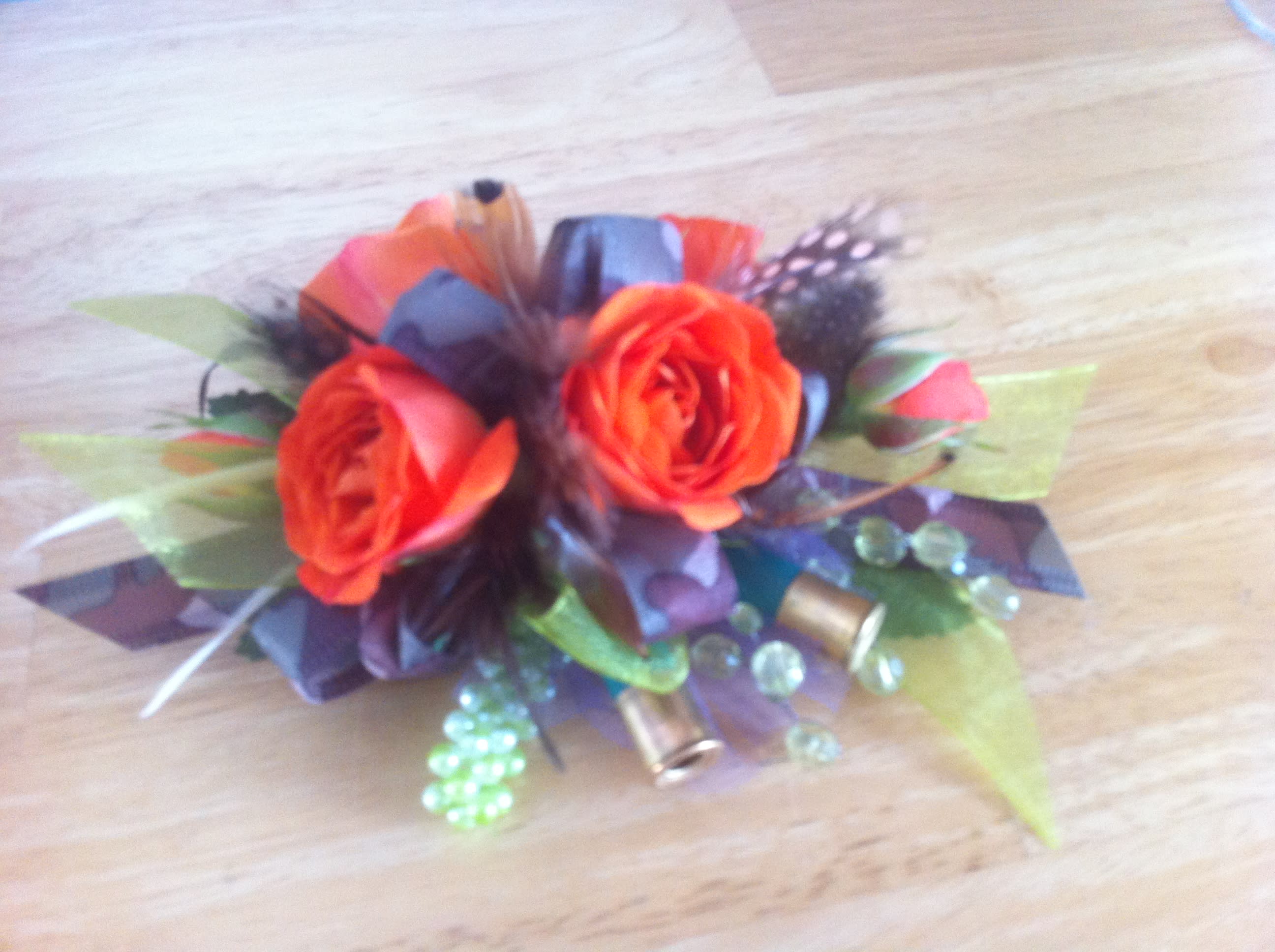 Small bouquet of orange roses with decorative beads and ribbon