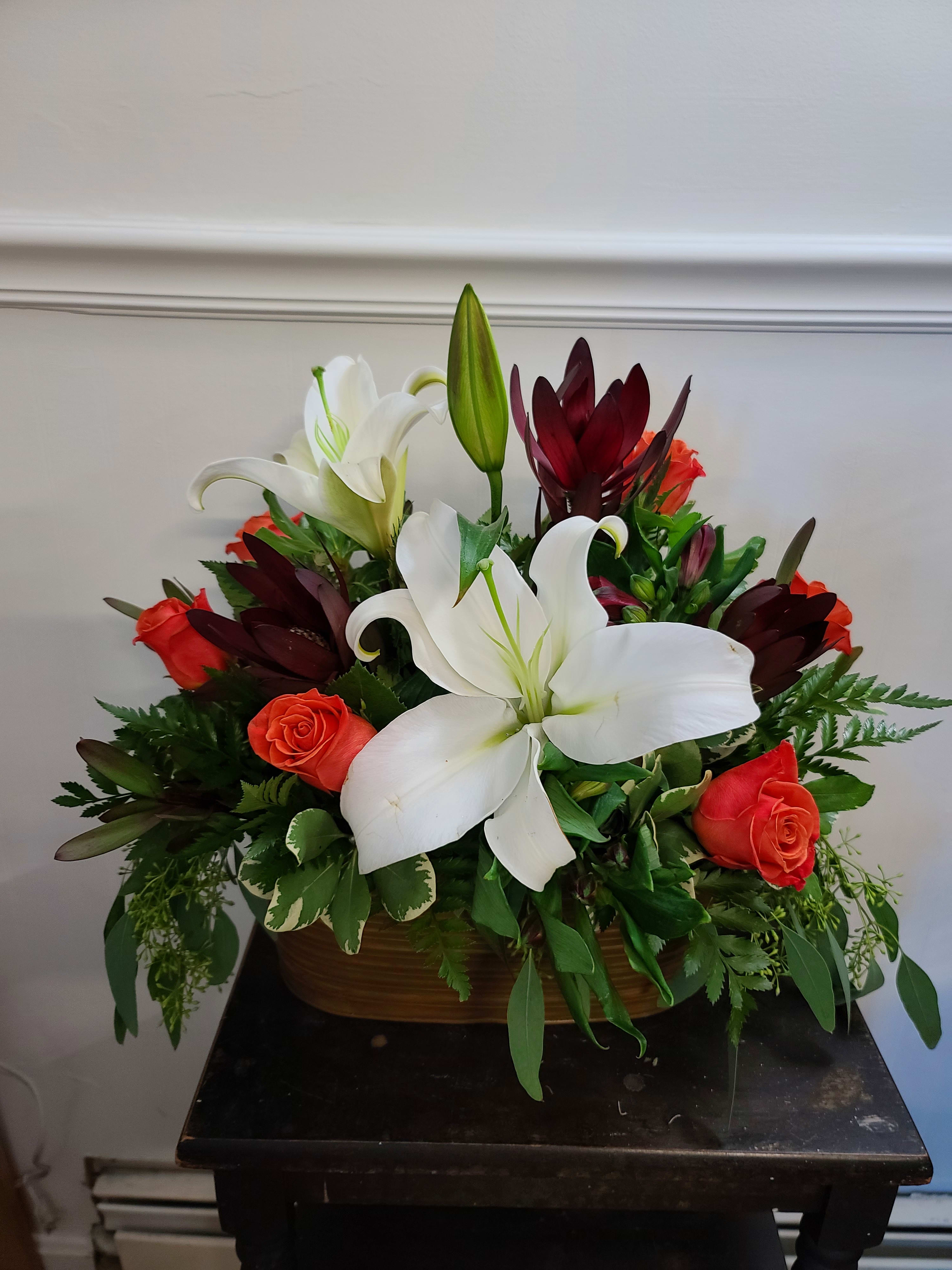 Amazing Grace - A simple arrangement of White Lilies and colorful roses mixed with an assortment of greenery and presented in a rustic container. Perfect for an at-home or business event. An excellent all purpose selection. Exact container may vary. 