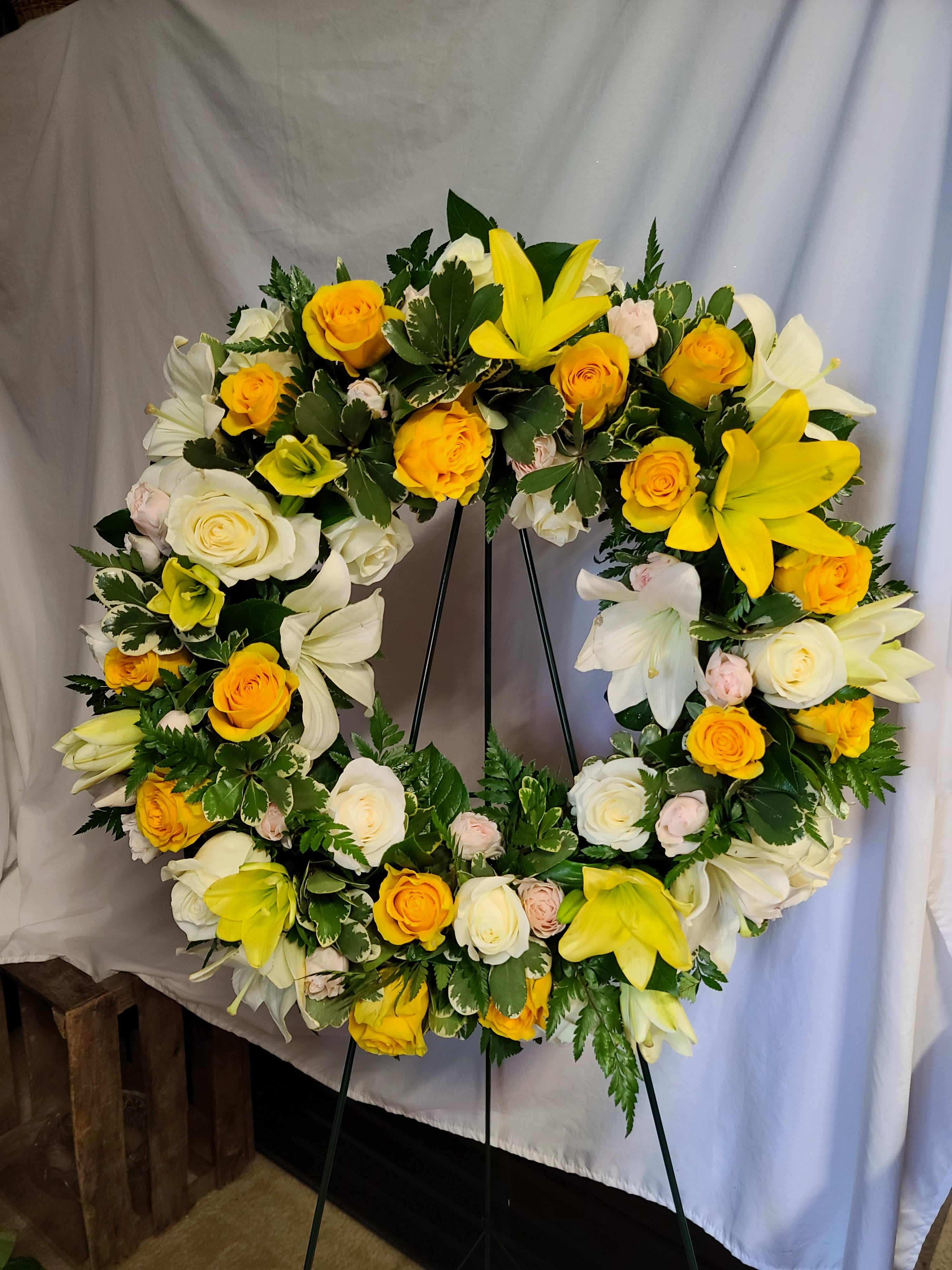 Yellow &amp; Cream Sympathy Wreath  - Yellow and White Lilies and Roses in a wreath of variegated greenery accented with a yellow ribbon 