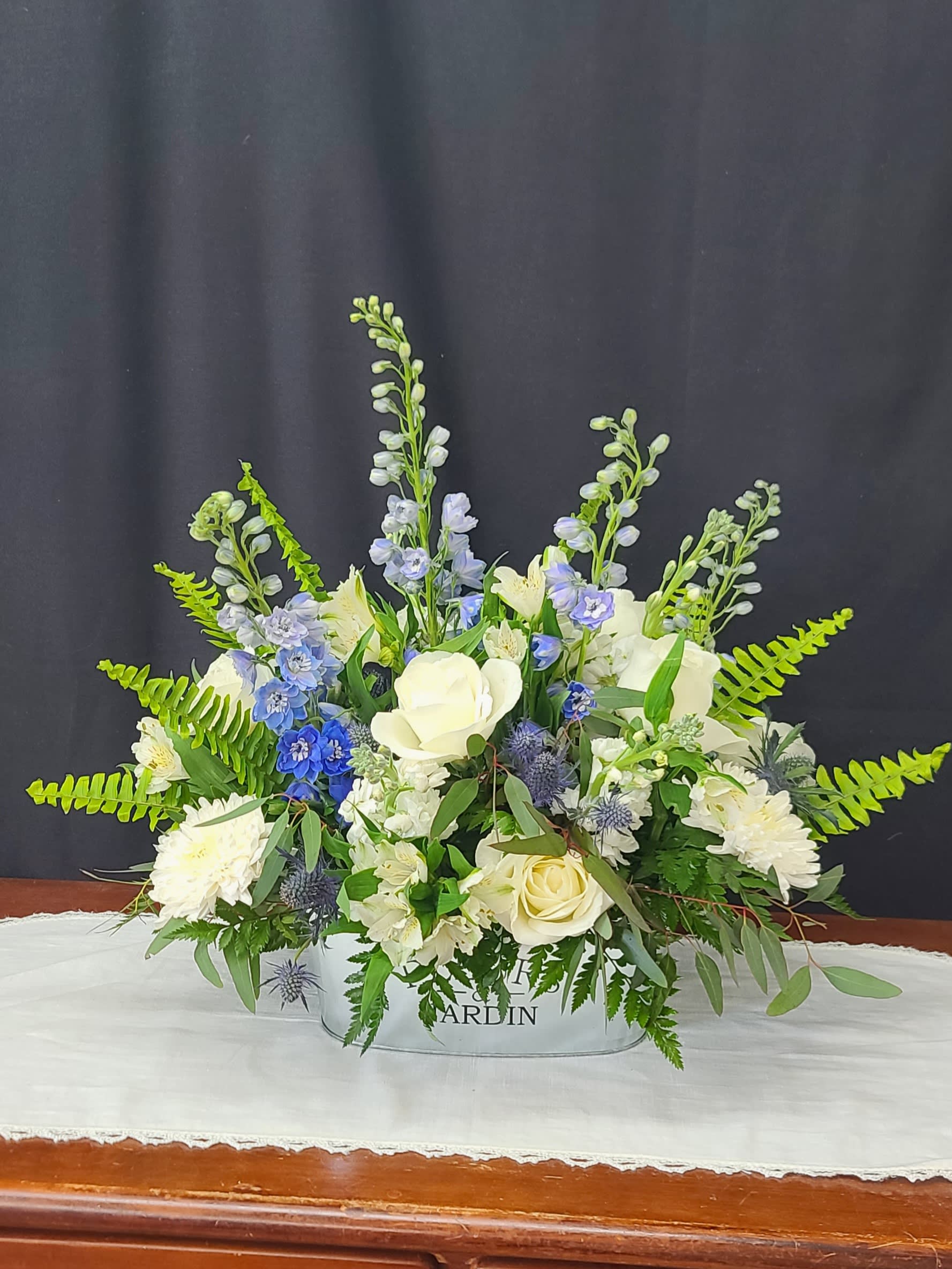 White and blue floral arrangement in a low container
