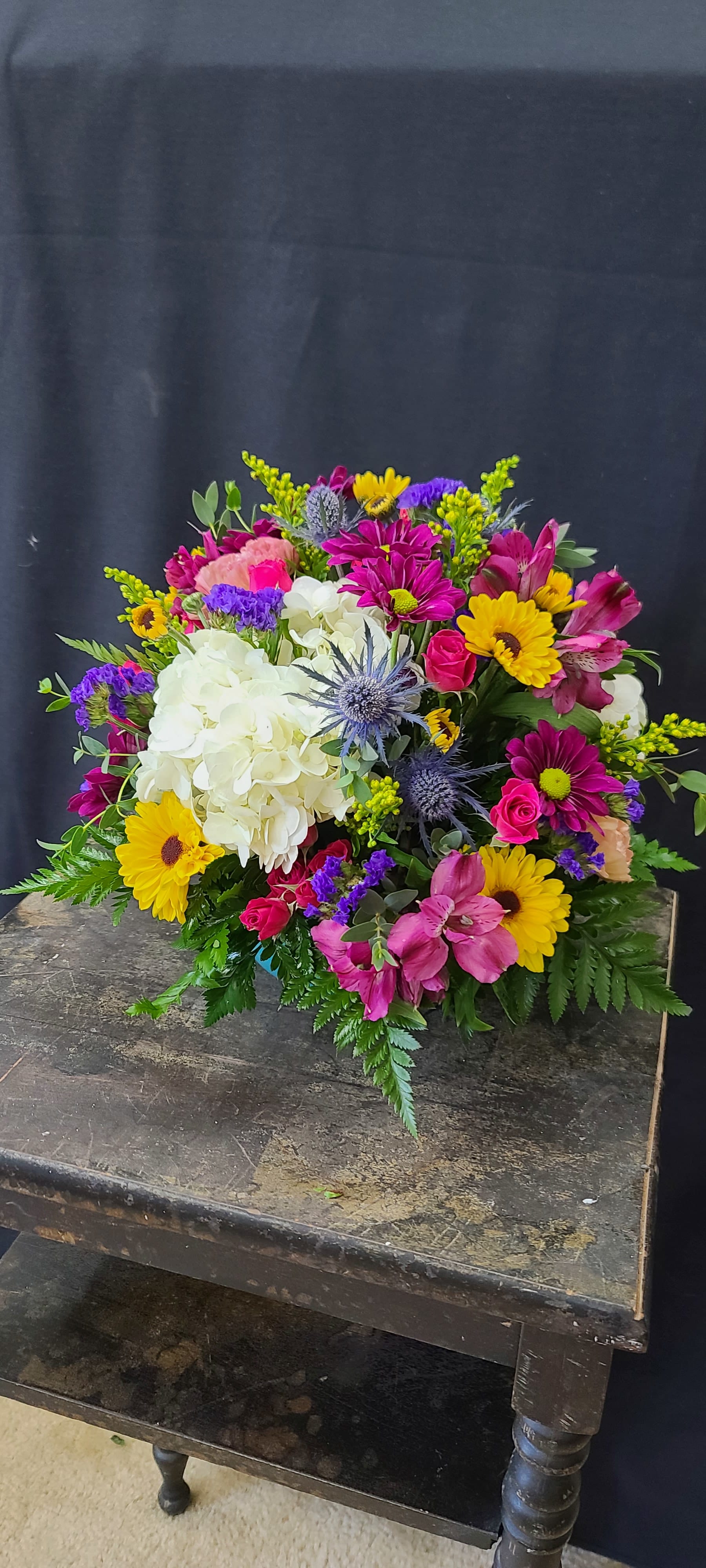Mixed bouquet with white hydrangea, yellow daisies, and pink flowers