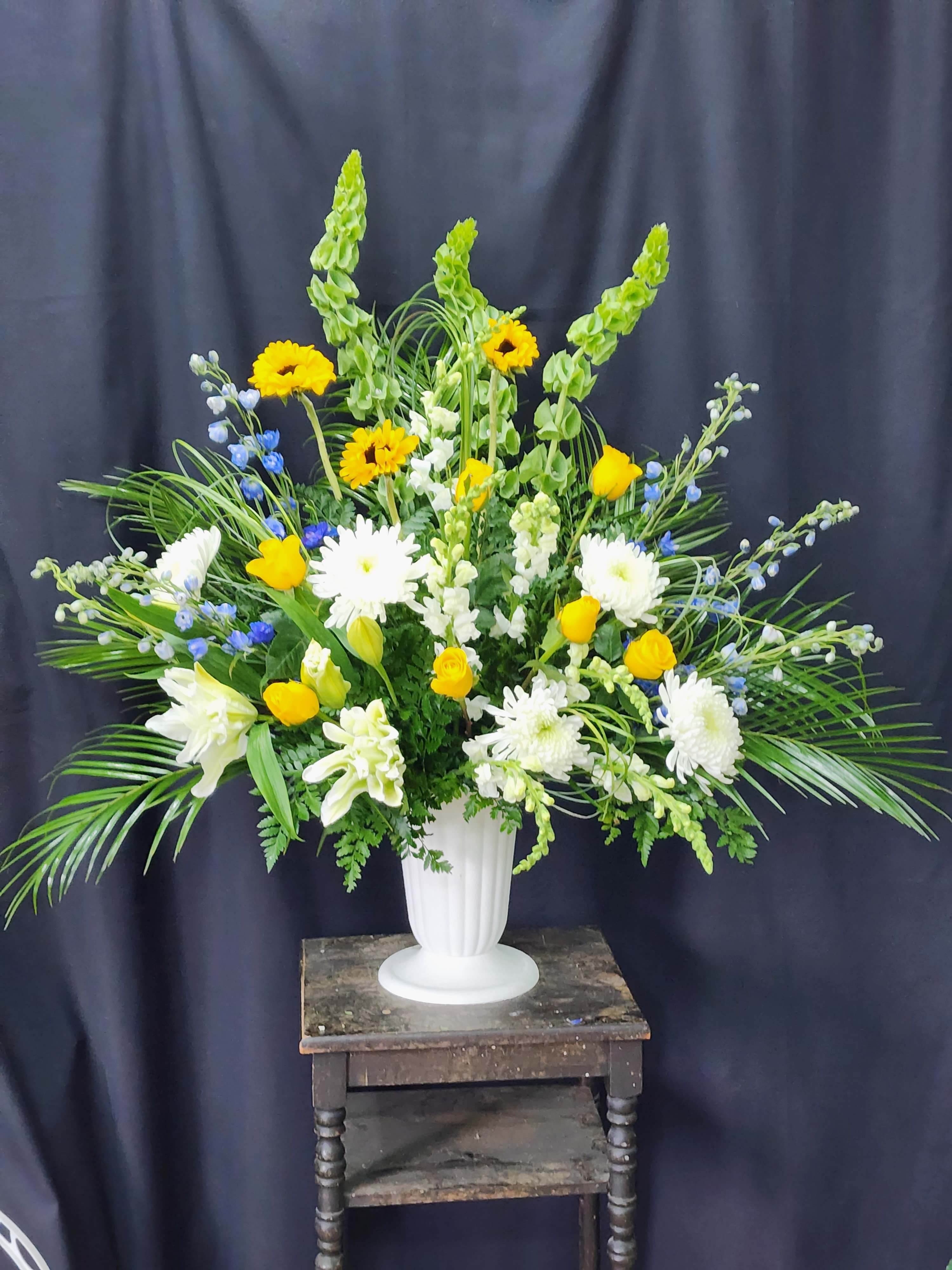 Large white vase arrangement with yellow and white flowers