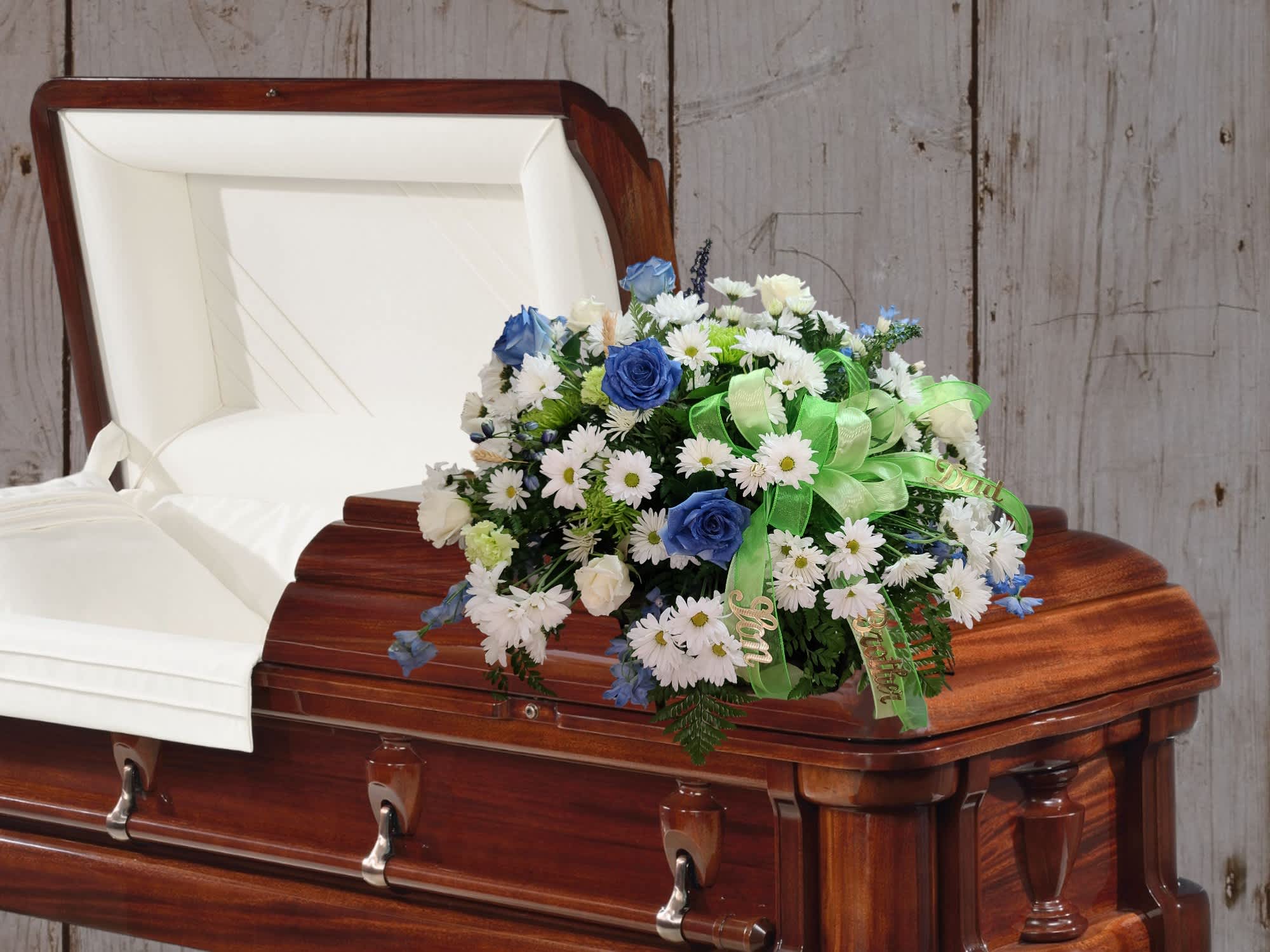 White and blue floral spray on a wooden casket