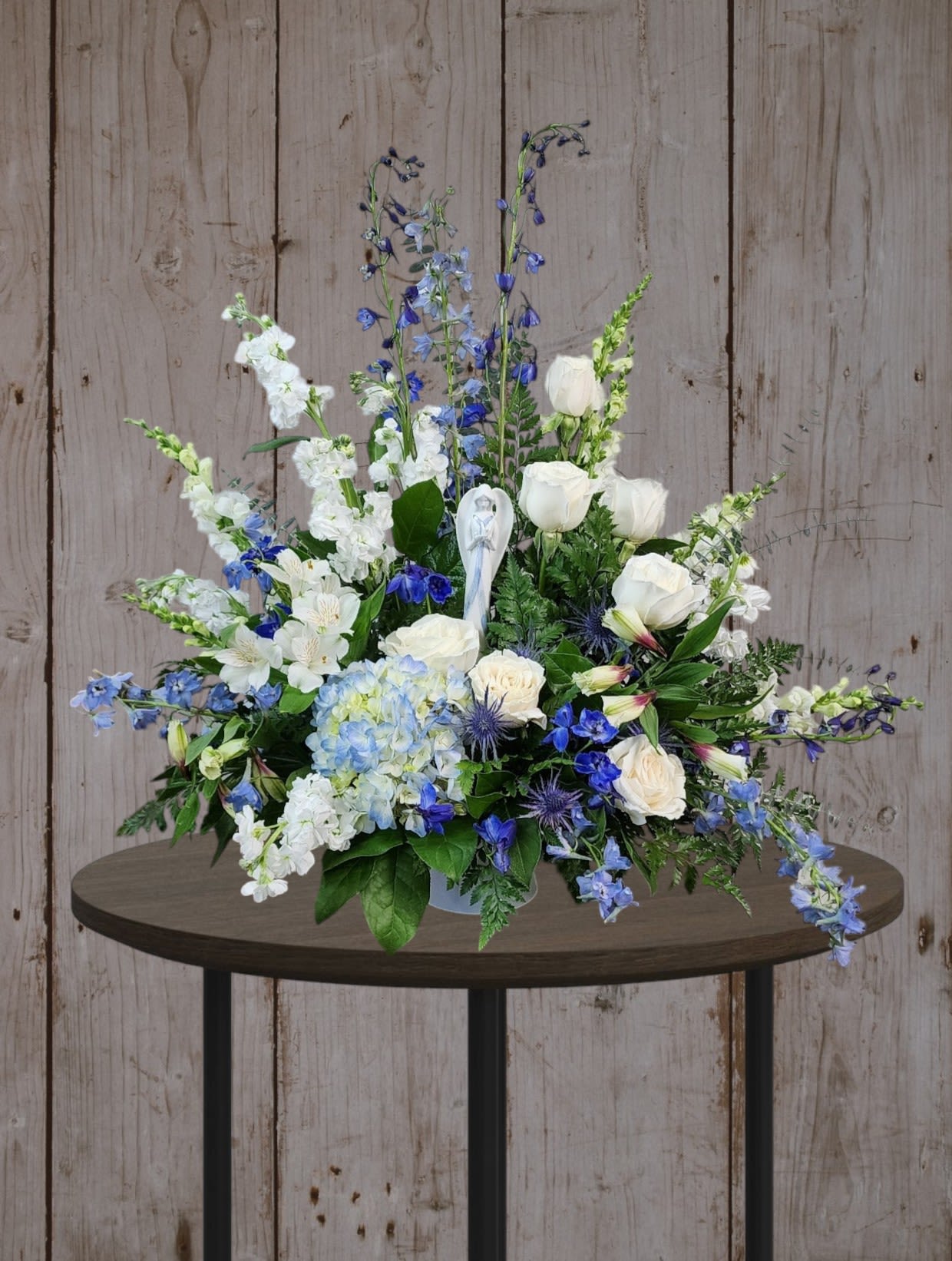 Blue and white floral arrangement in a vase on a table