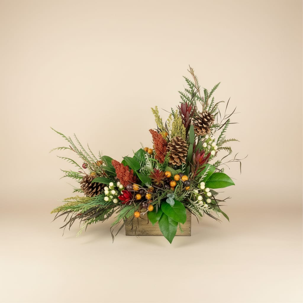 Rustic arrangement with pinecones, berries, and greenery in a wooden box