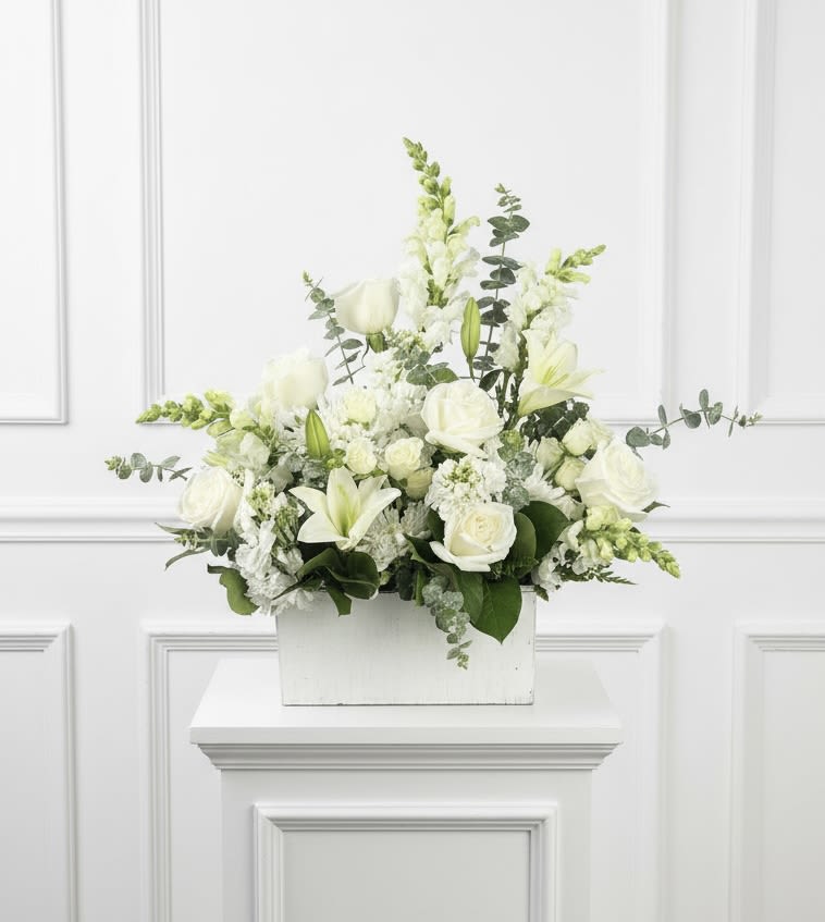 White floral arrangement in a white rectangular container