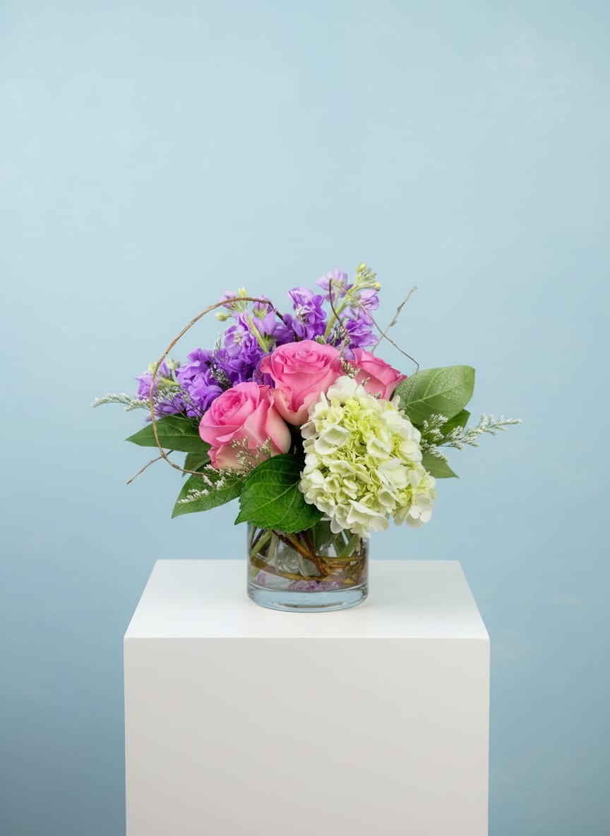 Pink roses and purple flowers in a glass vase