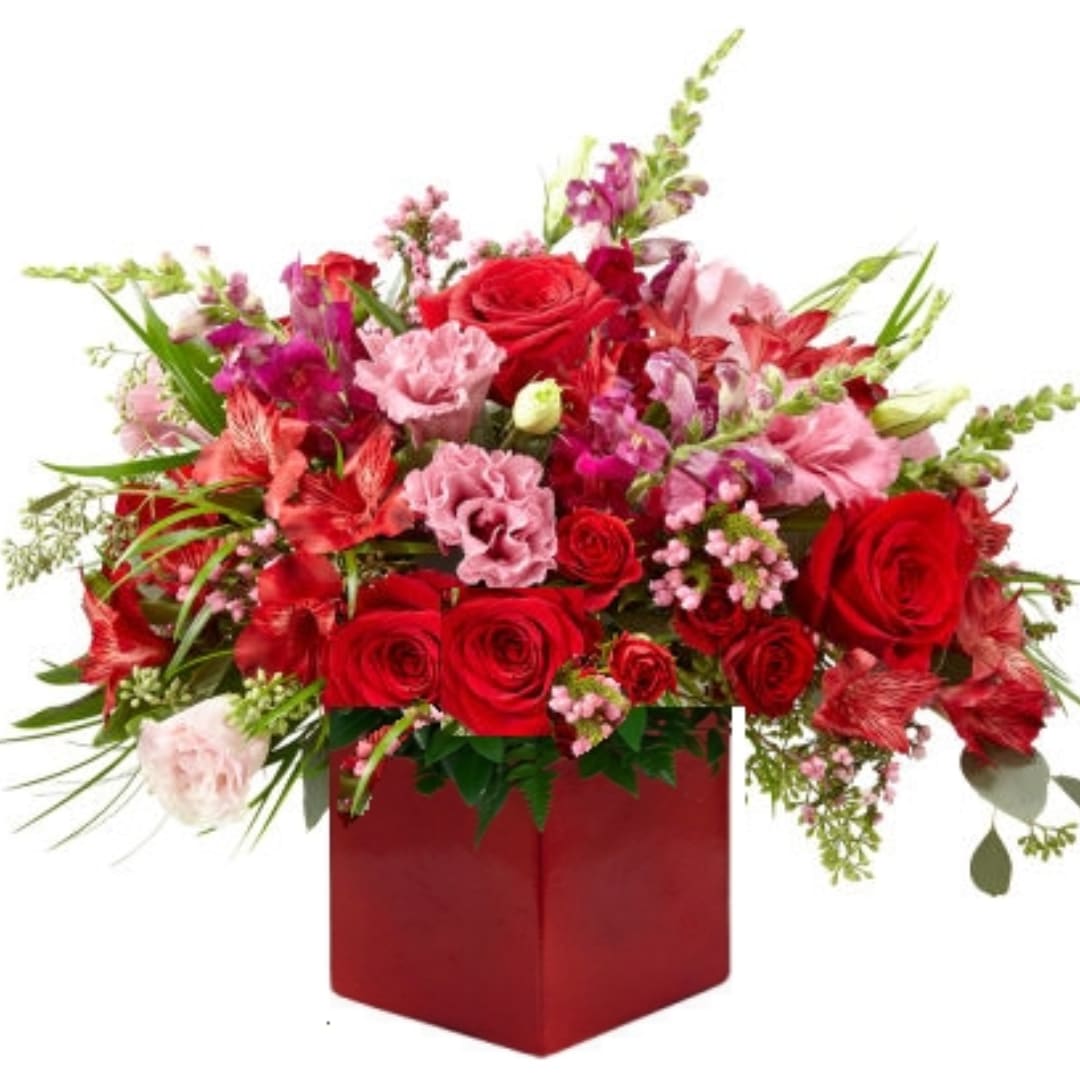 Red and pink mixed flower arrangement in a red box