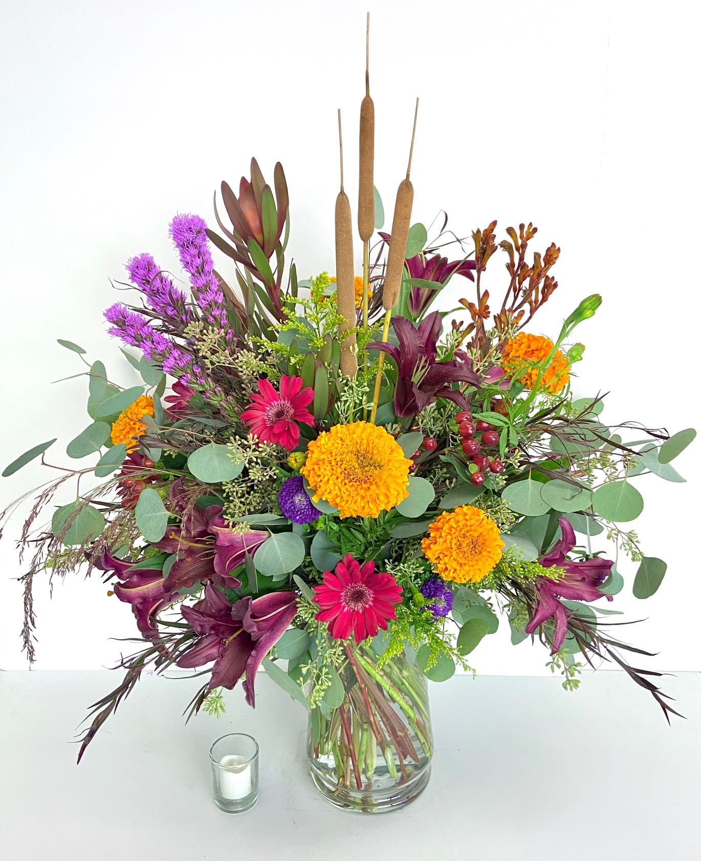 Autumn Splendor - A lush vase design of richly colored autumn blooms, accented with cattails, kangaroo paw, and an organic base of mixed eucalyptus. 