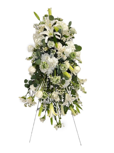 White funeral spray with lilies and roses on a standing easel