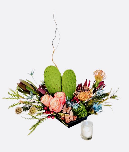 Floral arrangement with pink roses, protea, and cactus pads in a black container