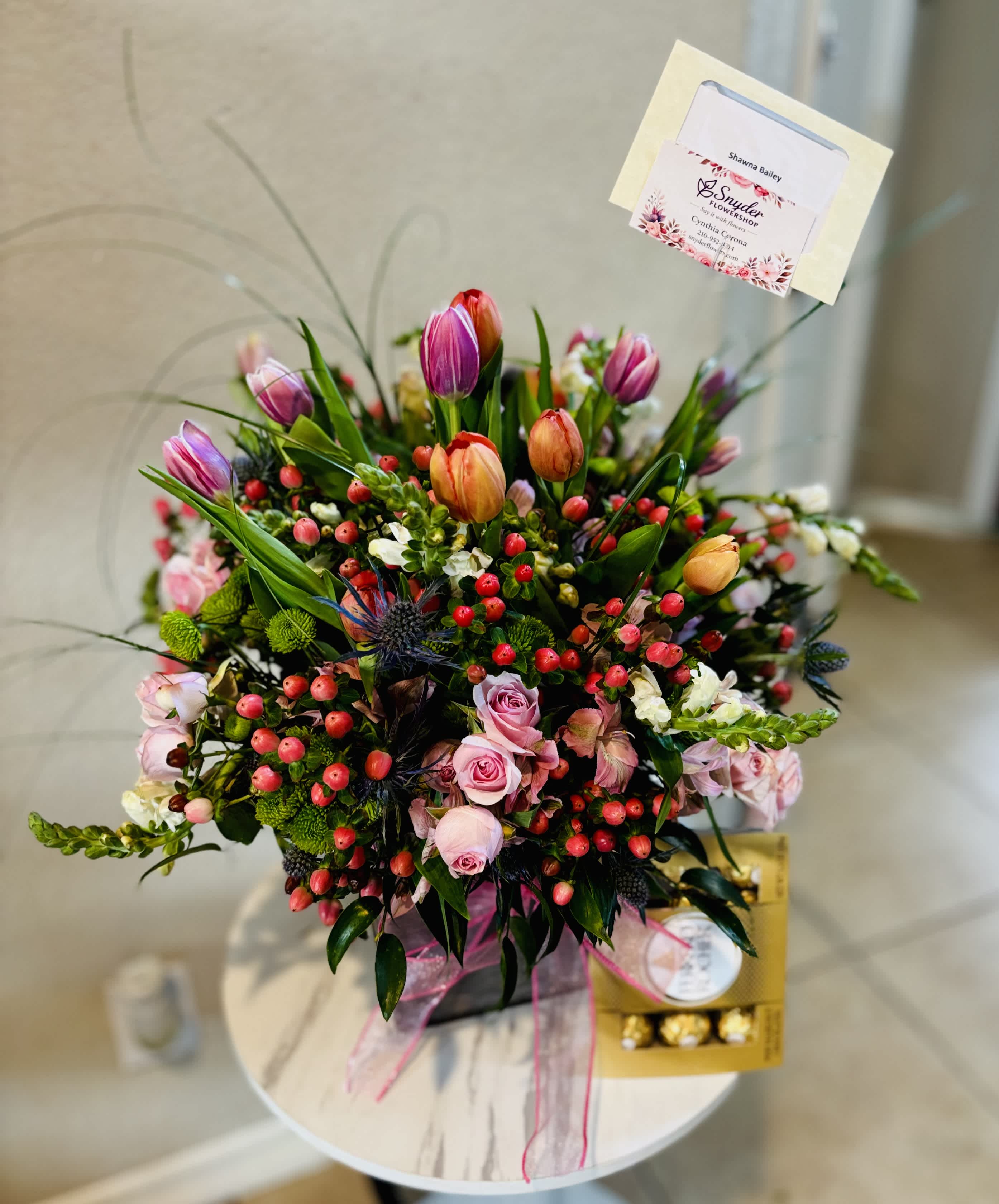 Mixed bouquet with pink roses, tulips, and berries in a gift box