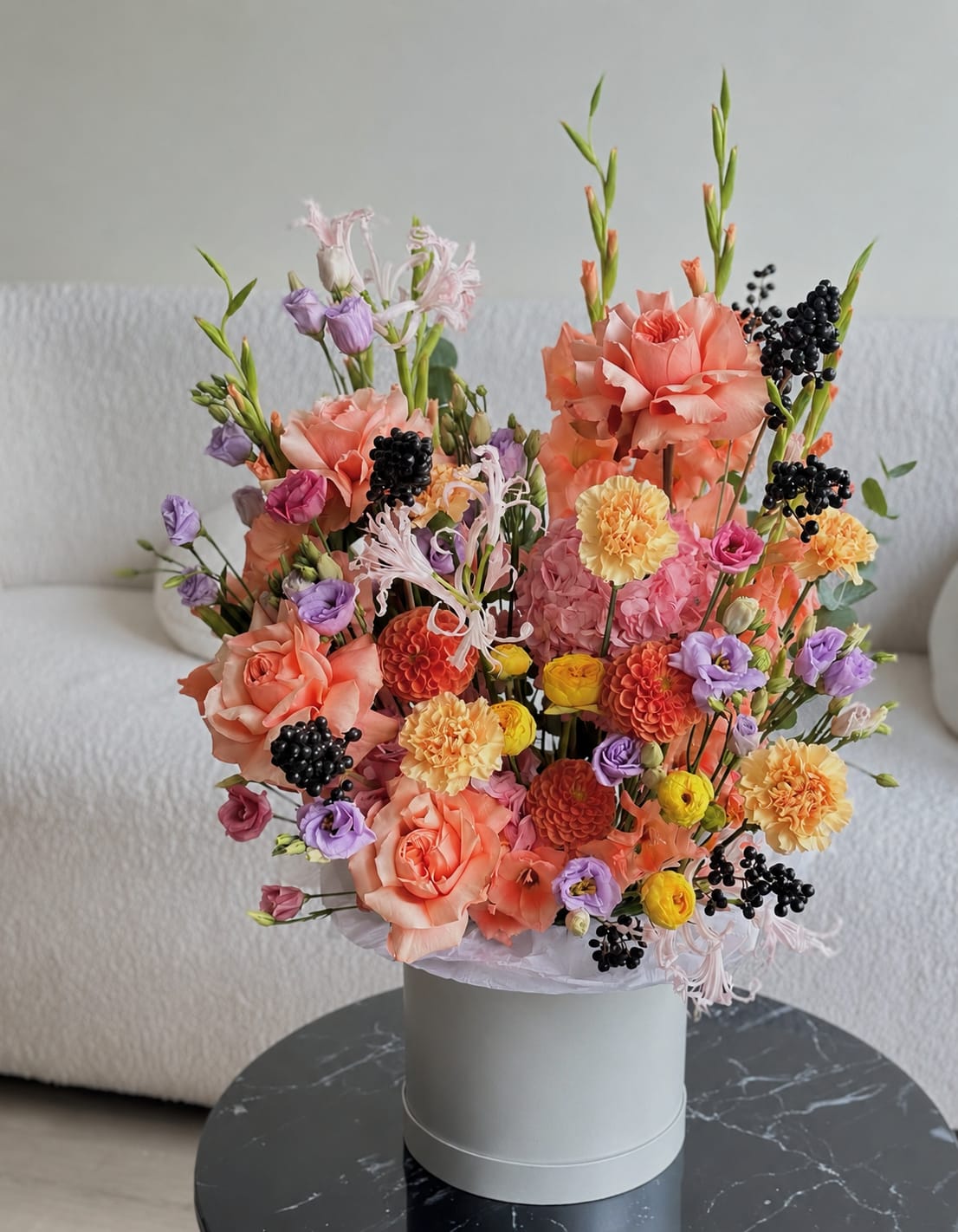 Mixed bouquet of peach, pink, purple, and yellow flowers in a white hat box