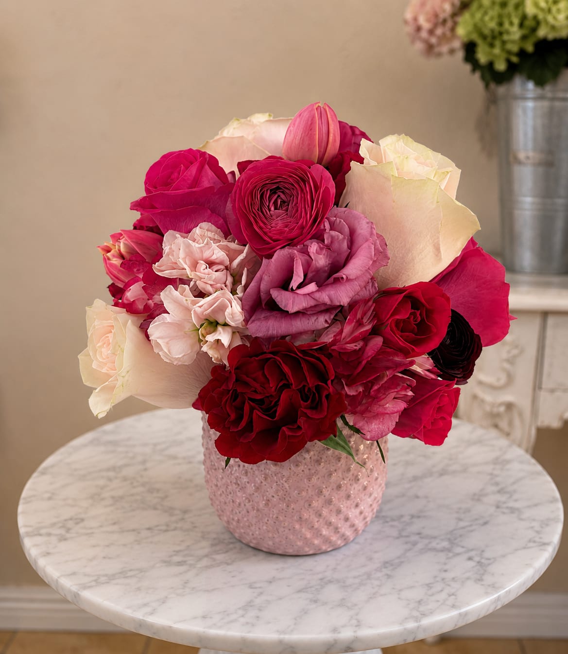 Pink and red rose bouquet in a textured pink vase