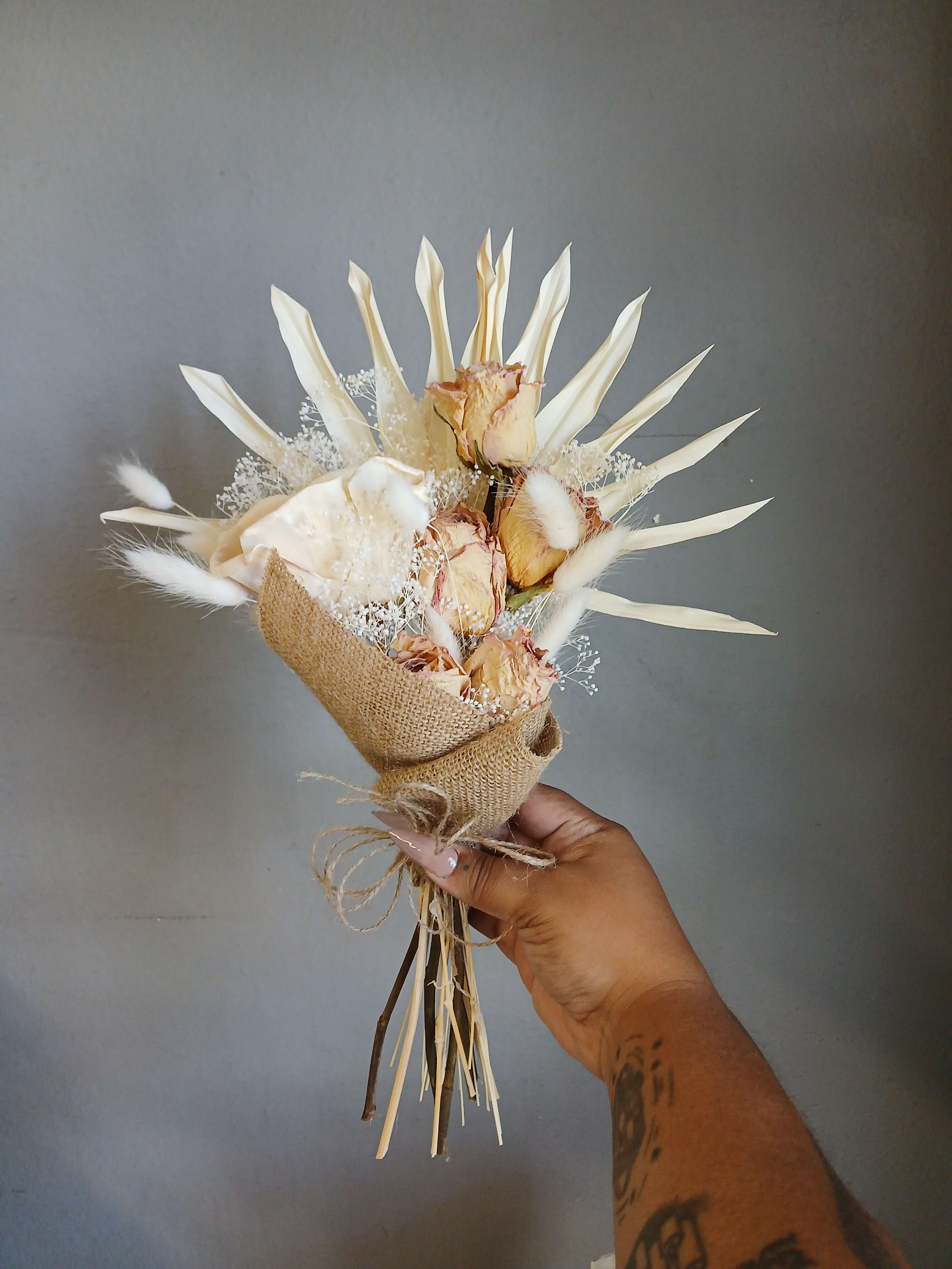 Small bouquet of dried cream roses wrapped in burlap