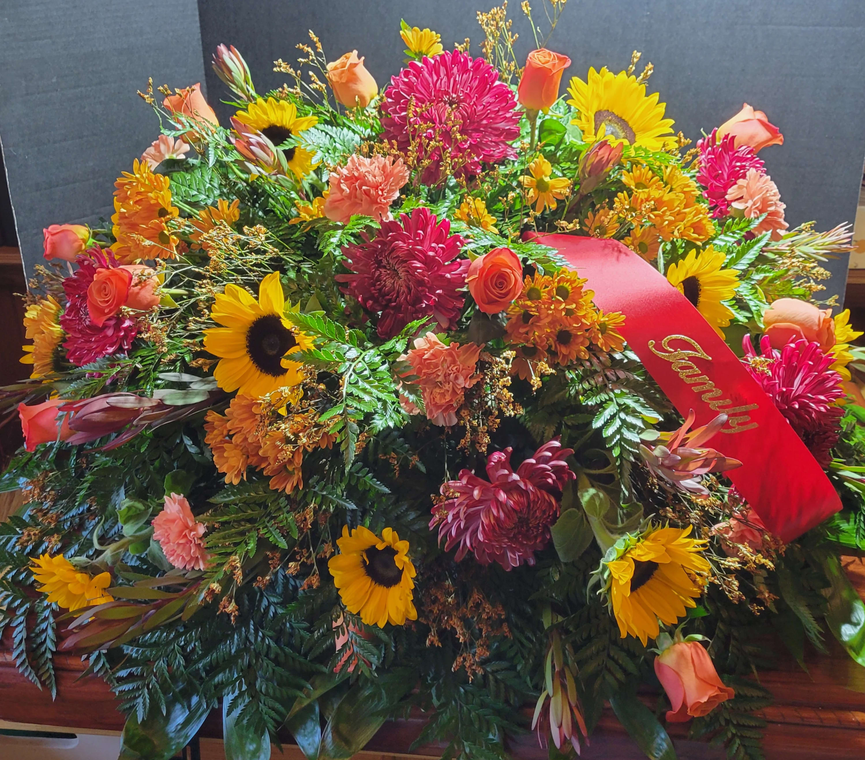 Large mixed floral arrangement with sunflowers, roses, and chrysanthemums