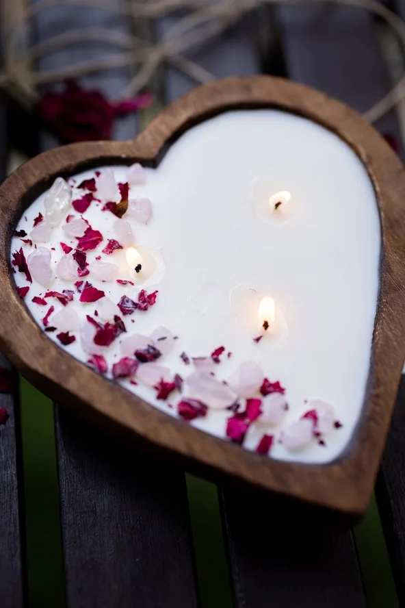 Heart-shaped candle with pink and red petals