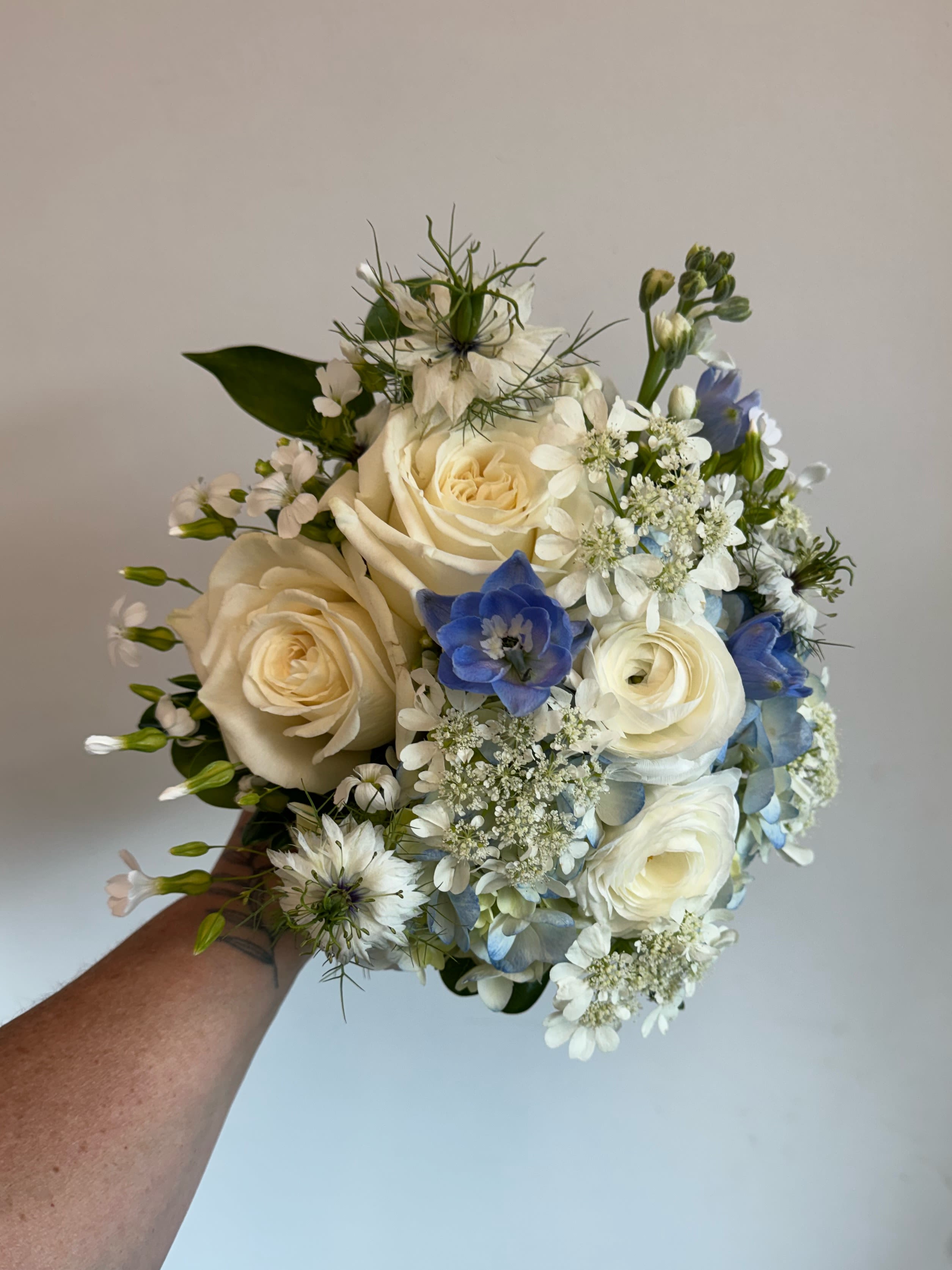 Blue and white hand held bouquet - This Instagram worthy bouquet will stand out and make your pictures look fabulous!  Shades of blues and whites are creatively designed into a beautiful bouquet.  Substitutions may be needed but will remain the same color scheme.