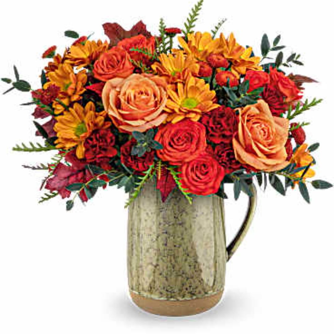 Bouquet of orange and red flowers in a rustic ceramic pitcher