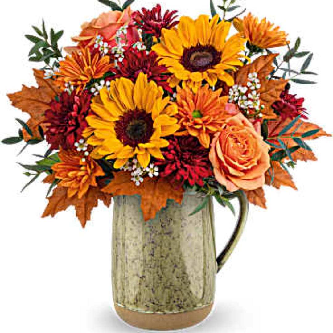 Autumn bouquet of sunflowers, roses, and mums in a metal pitcher