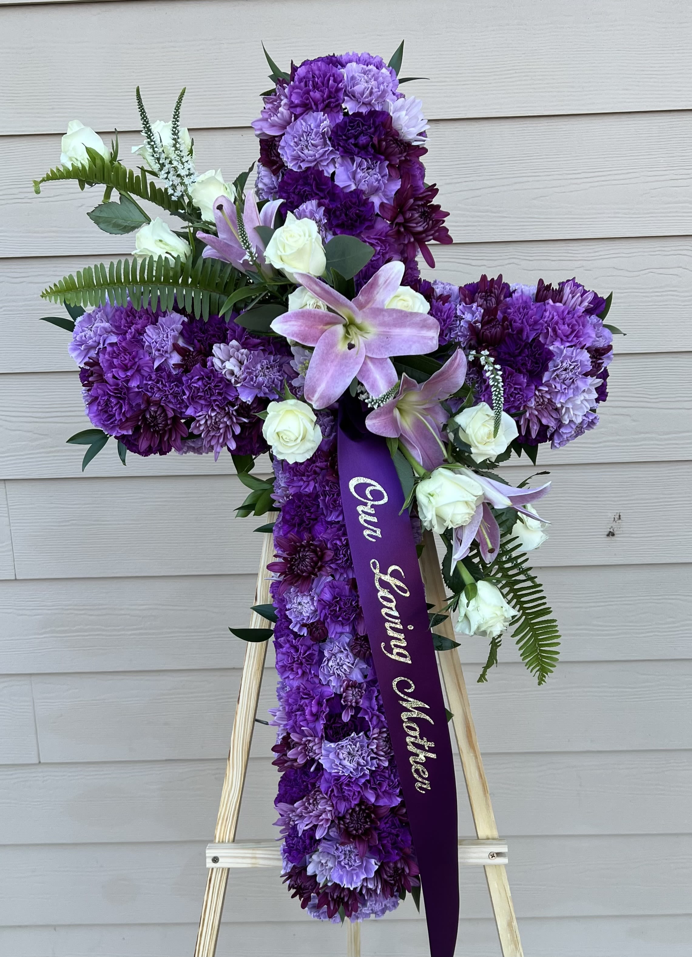 Cross of Beauty by Grohe Florists - A Vibrant and Beautiful Cross funeral spray is Stunning. Choose either Pink Or Purple Cross. Featuring a variety of coloreful flowers, this elegant easel compliments the beauty of life. 