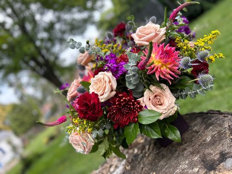 Bouquet of pink roses, burgundy blooms, and purple flowers