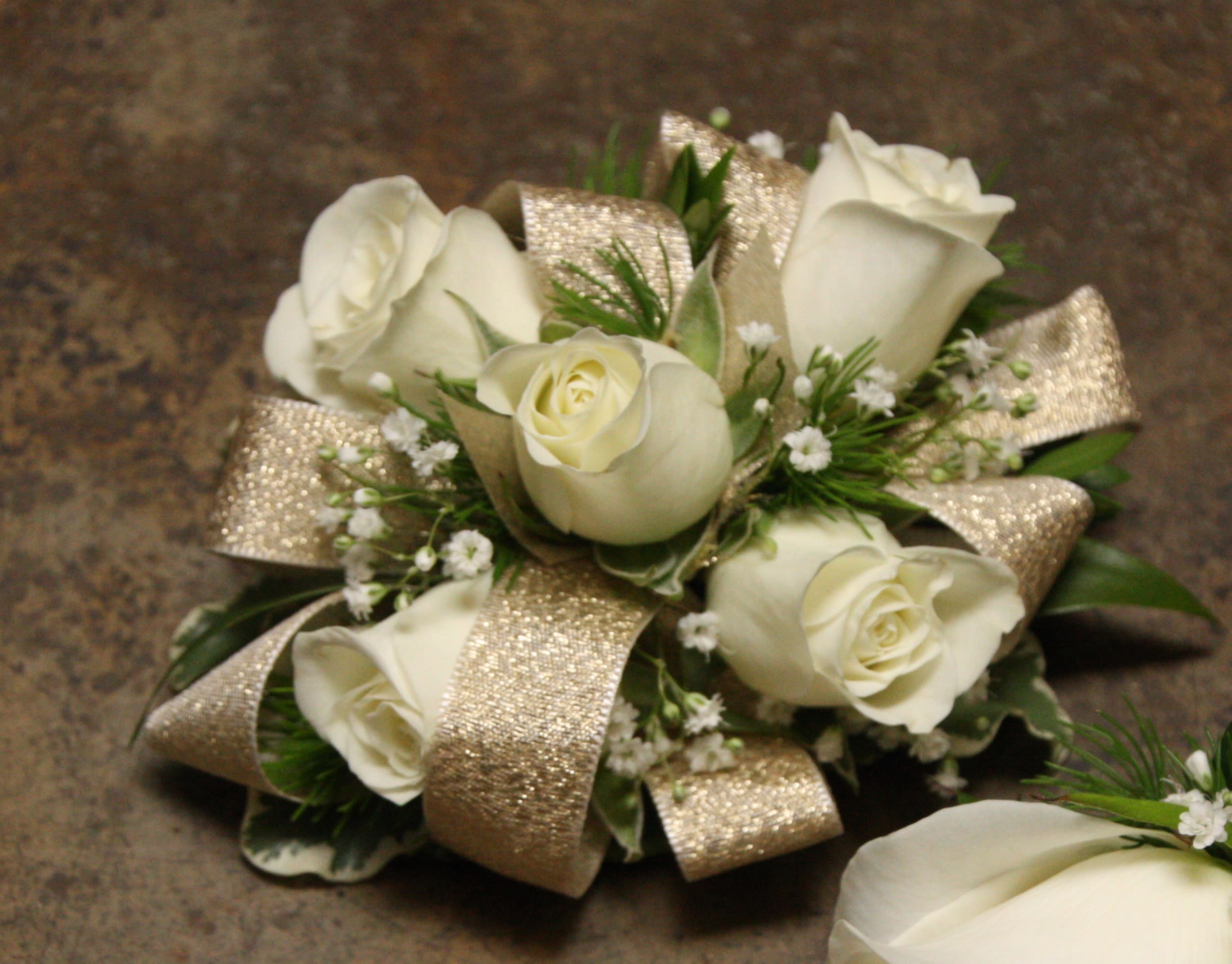 Golden Rose Wristlet - Select this corsage of white spray roses, babies breath and gold ribbon. ALL PROM FLOWERS ARE AVAILABLE IN COLORS PICTURED OR A CUSTOM SELECTION. CHOOSE YOUR FLOWER COLORS, RIBBON COLOR AND ANY ADD ONS. FOR QUESTIONS CALL A FRIENDLY SALES REPRESENTATIVE AT STRELITZIA FLOWER CO.