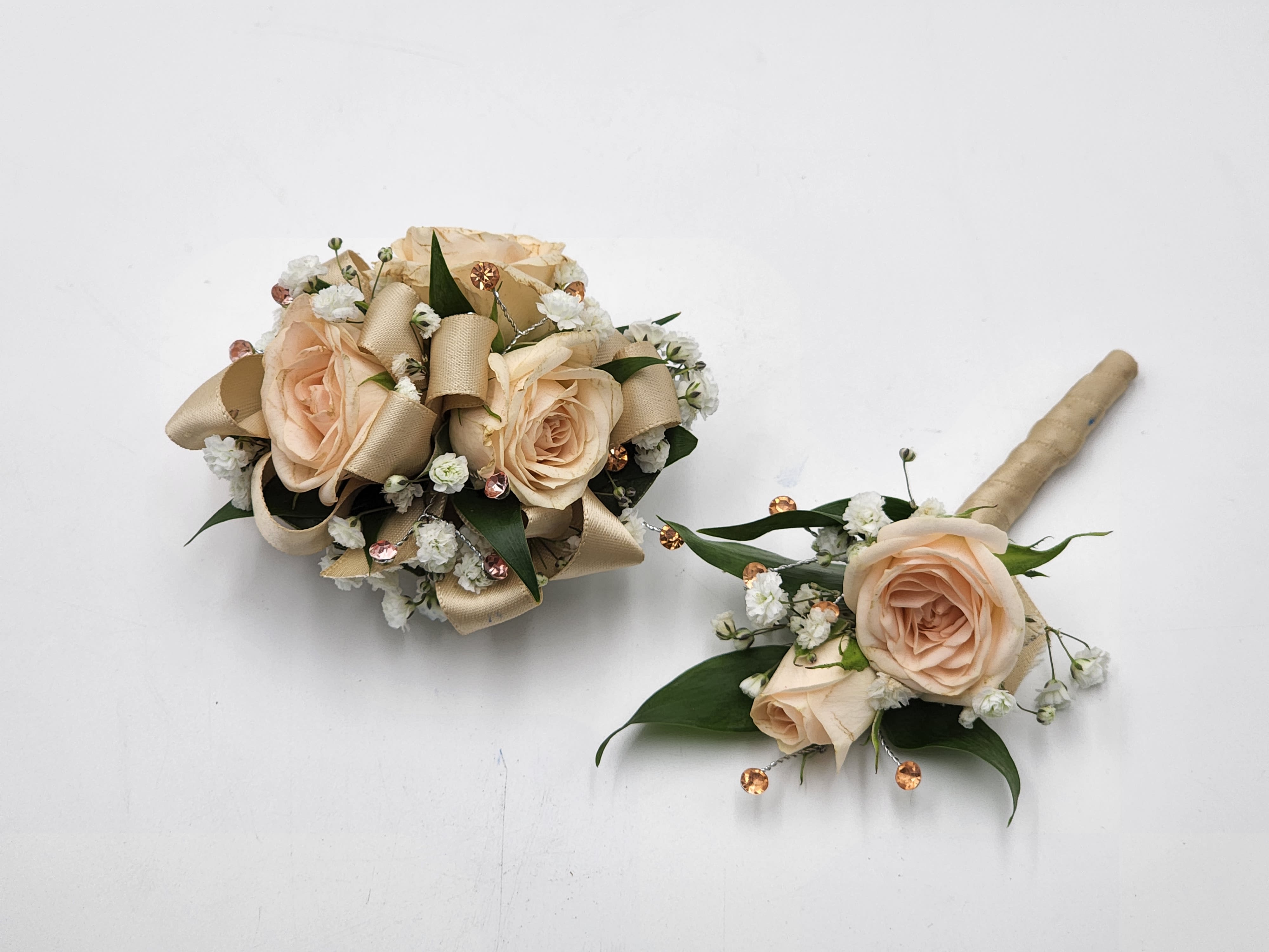 Peaches and Cream Boutonniere And Wristlet Set - A boutonniere and wrist corsage set featuring peach spray roses, peach ribbon and peach rhinestones.  Depending on availability of ribbon, may change slightly. Color of rhinestone bracelet may vary.