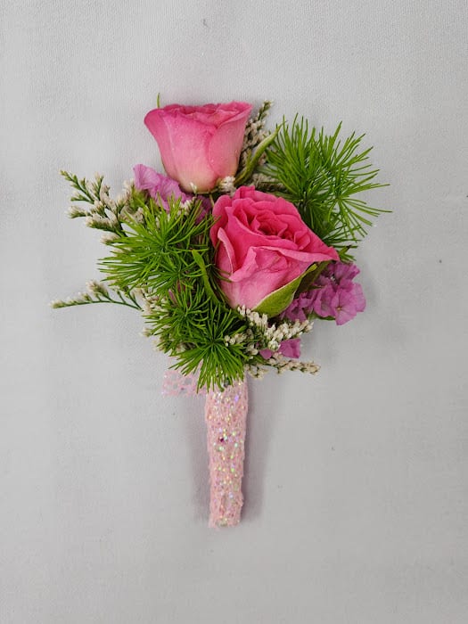 Barbie Boutonniere - Select this adorably pink boutonniere featuring spray roses, statice, and misty wrapped in pink ribbon.  Each boutonniere comes with two metal pins to pin on a jacket lapel or shirt.