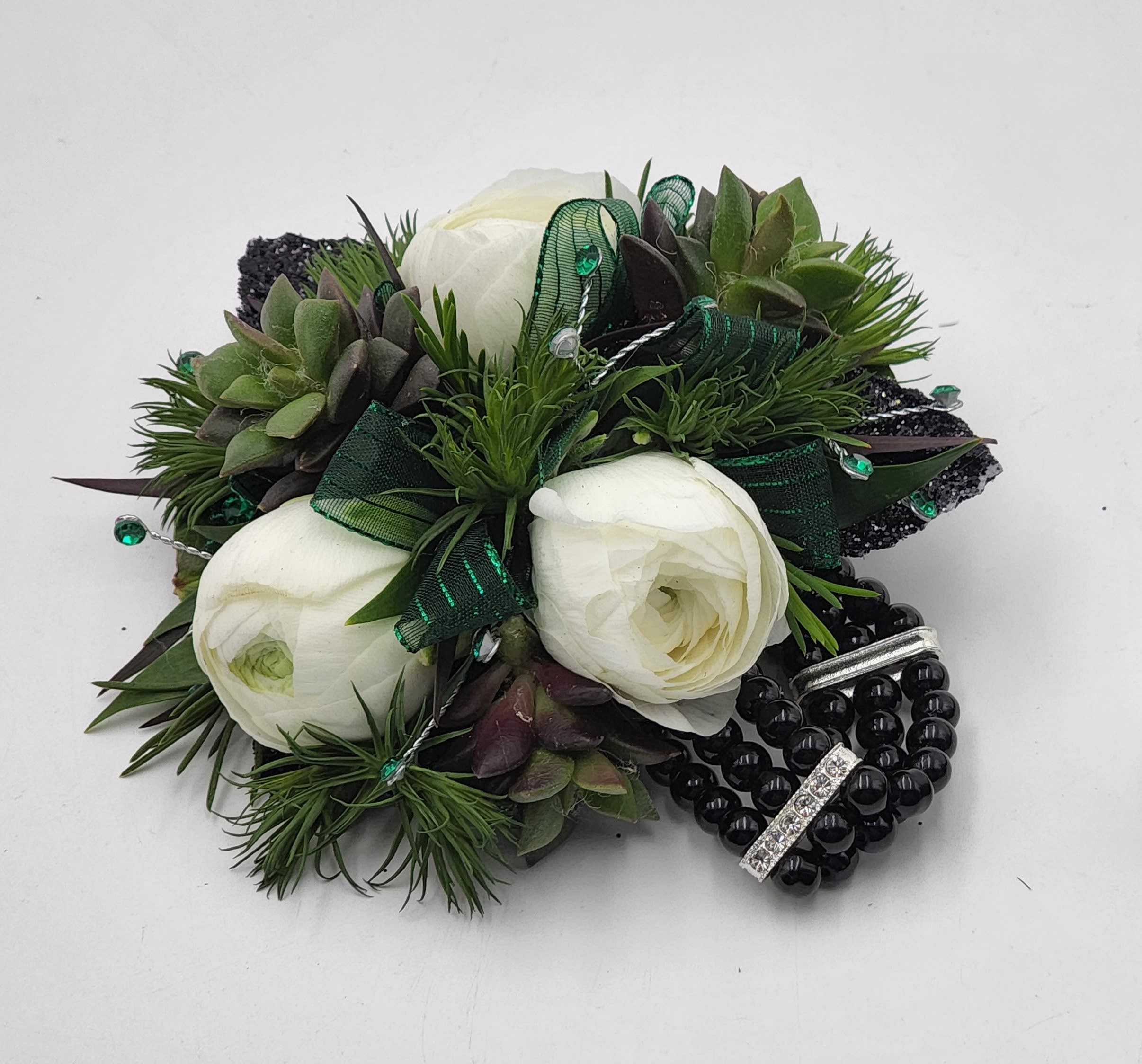 Fern Valley Wristlet - A  wrist corsage of white ranunculus, succulents, green ribbon and a black keepsake bracelet.  Depending on availability of ribbon, may change slightly.