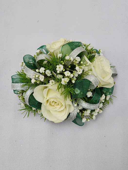 Slytherin Wristlet - A wrist corsage featuring white spray roses, babysbreath, greenery and two accenting ribbons. 