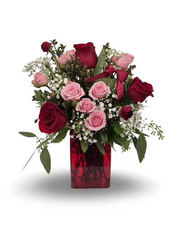 Lady in Red - Select this cute and traditional arrangement featuring roses, spray roses, ranunculus and babies breath. Made in a keepsake red vase, this make the perfect gift for someone special.  Approximately 14.5" x 11" x 8"