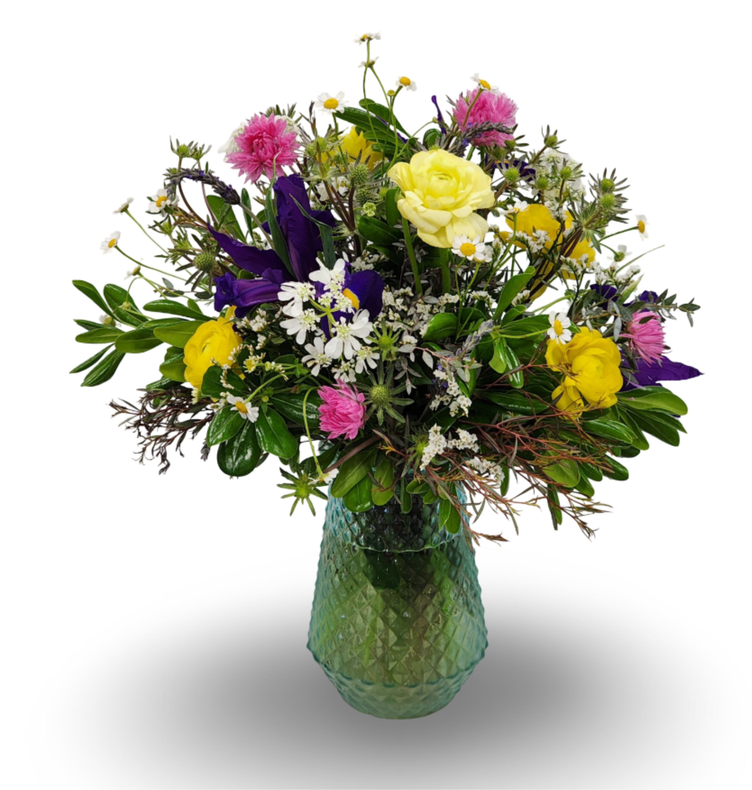 Mixed bouquet of yellow, pink, purple, and white flowers in a green glass vase