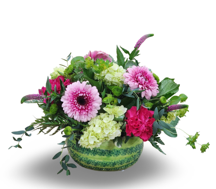Pink and green mixed flower arrangement in a round green vase