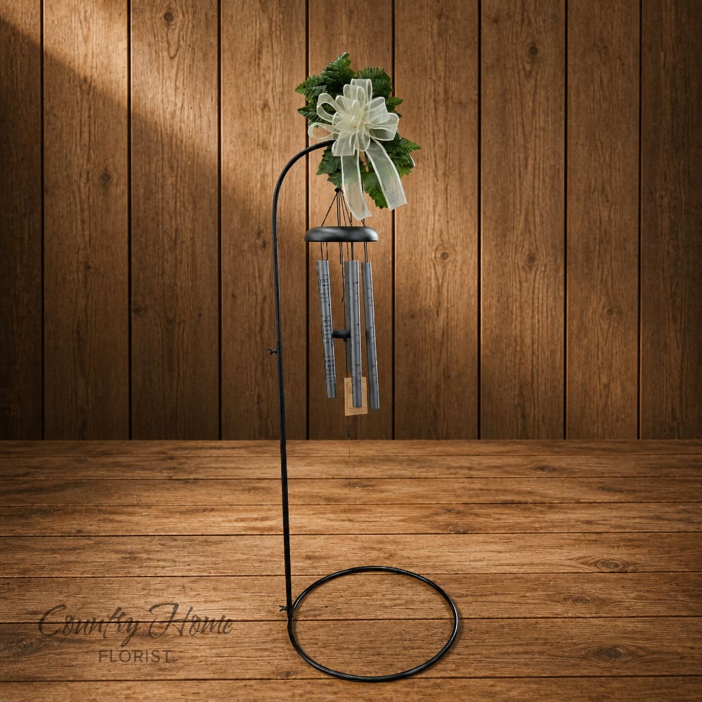 Wind chime with a white ribbon bow and greenery topper