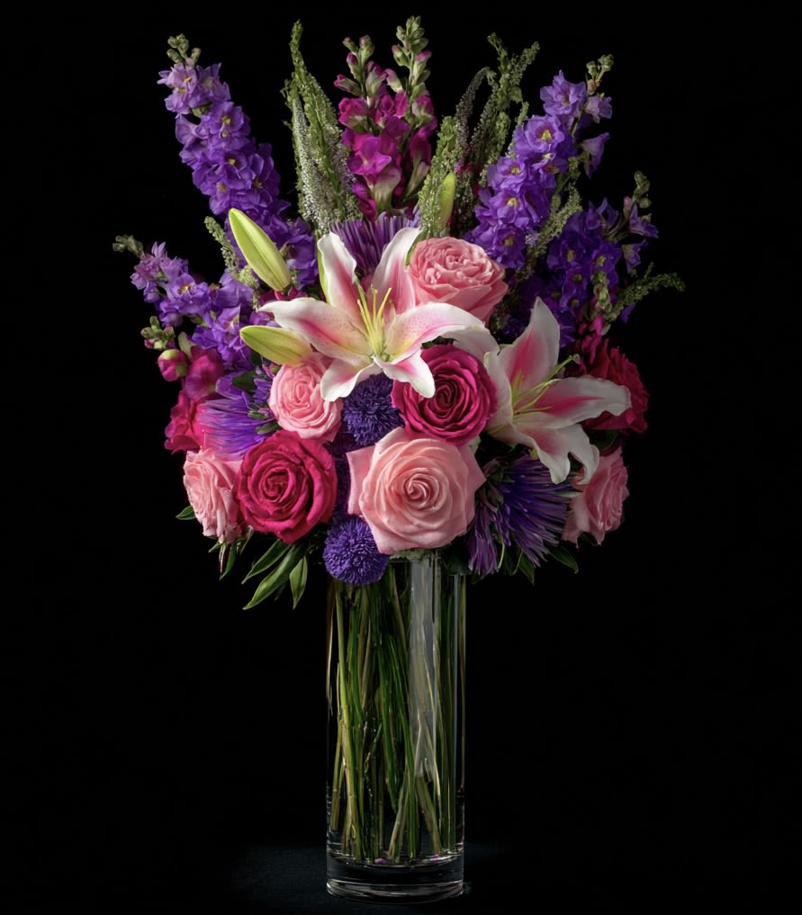 Radiant Reverie Bouquet -  Radiant Reverie Bouquet is a dramatic contrast of bold magentas and purples with the soft blush tones and star-like lilies, evoking a sense of dreamy luxury and striking beauty. 