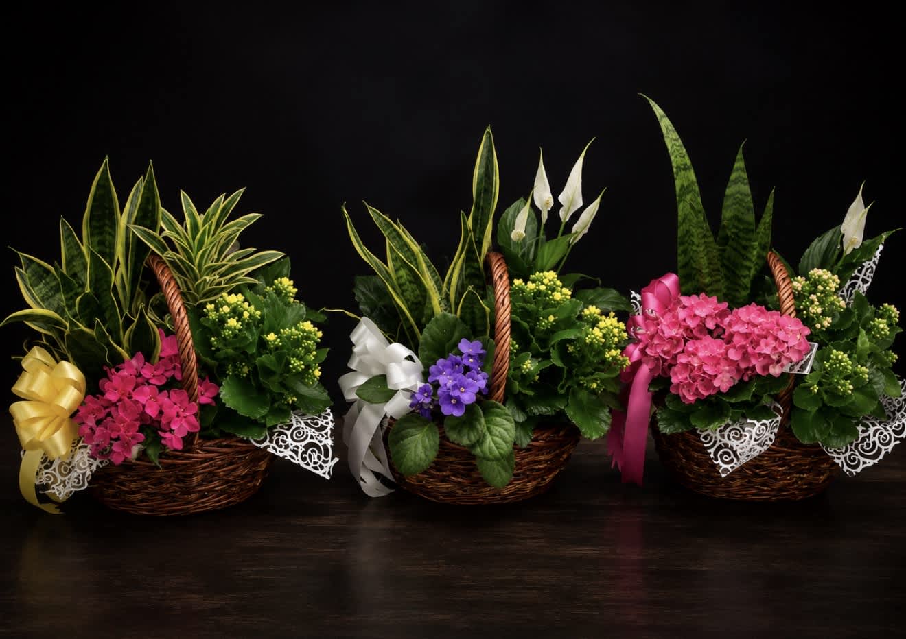 Three basket arrangements with mixed flowers and ribbon bows