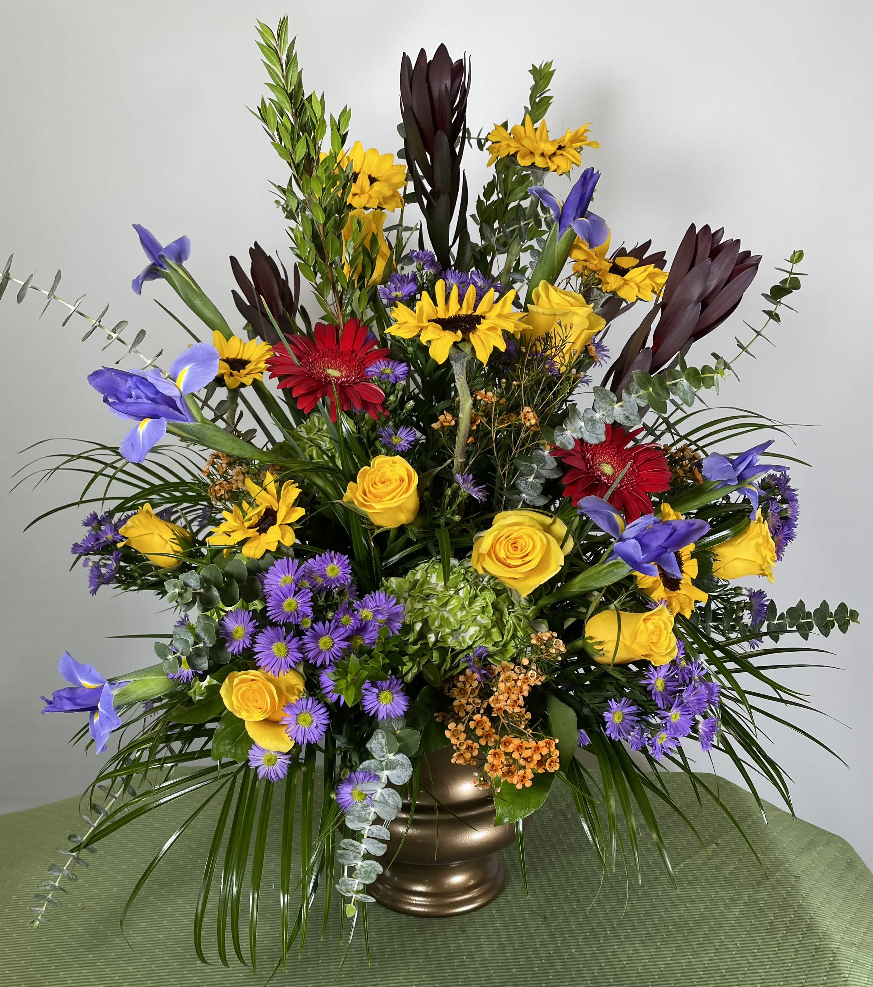 Colorful mixed flower arrangement in a bronze vase