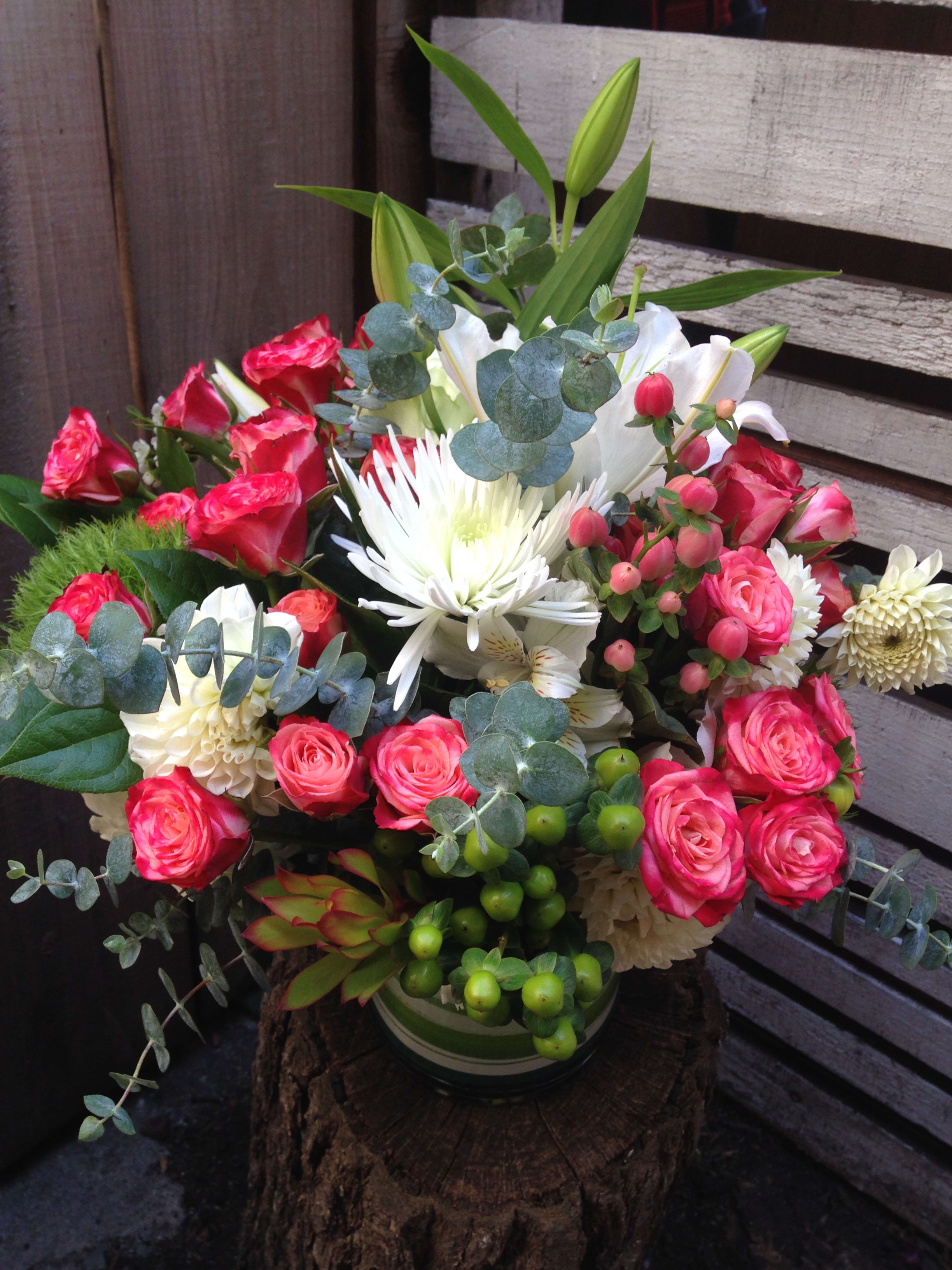 Bouquet of pink roses and white lilies in a vase with eucalyptus