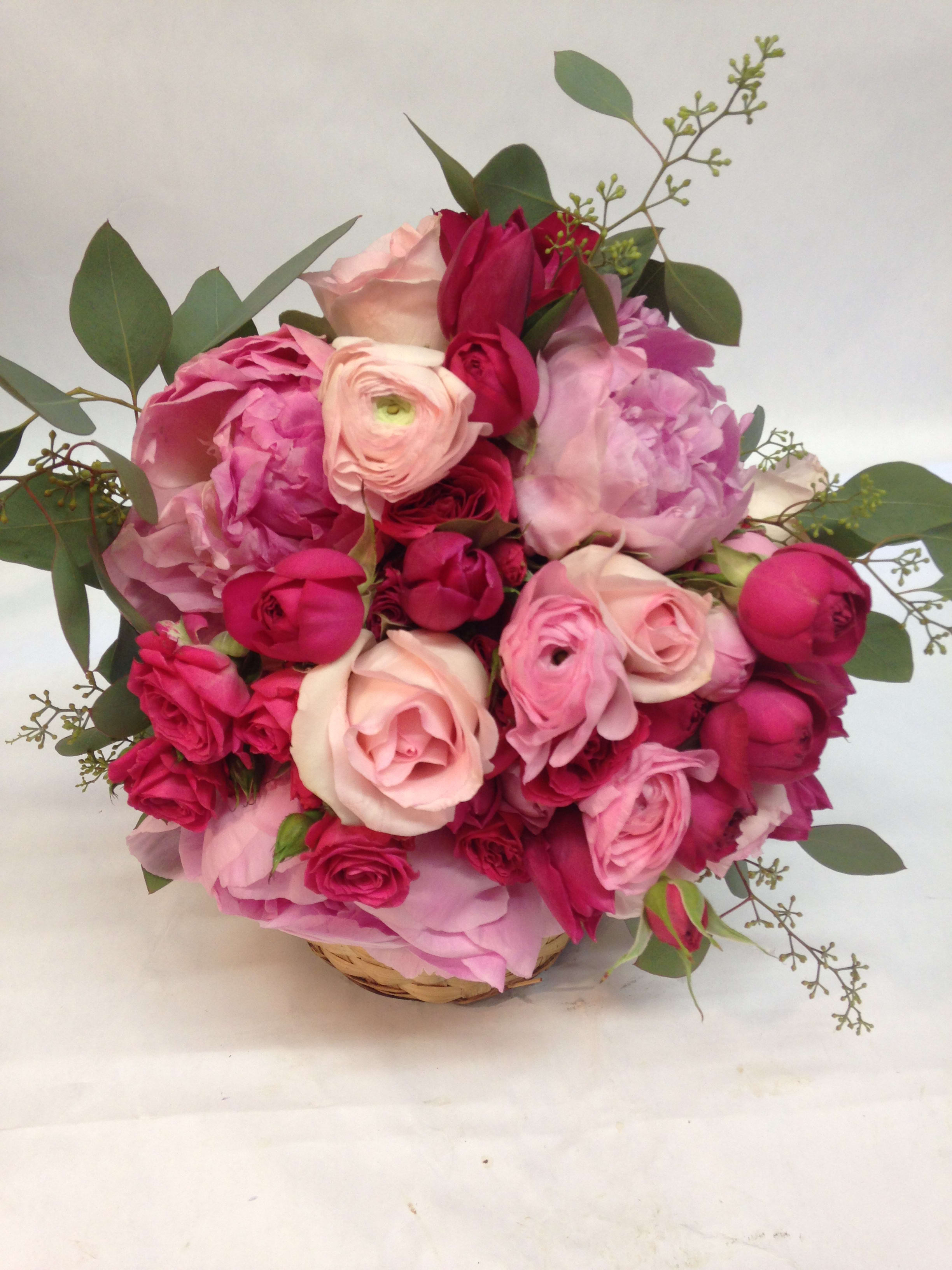 Pink and red rose bouquet in a woven basket