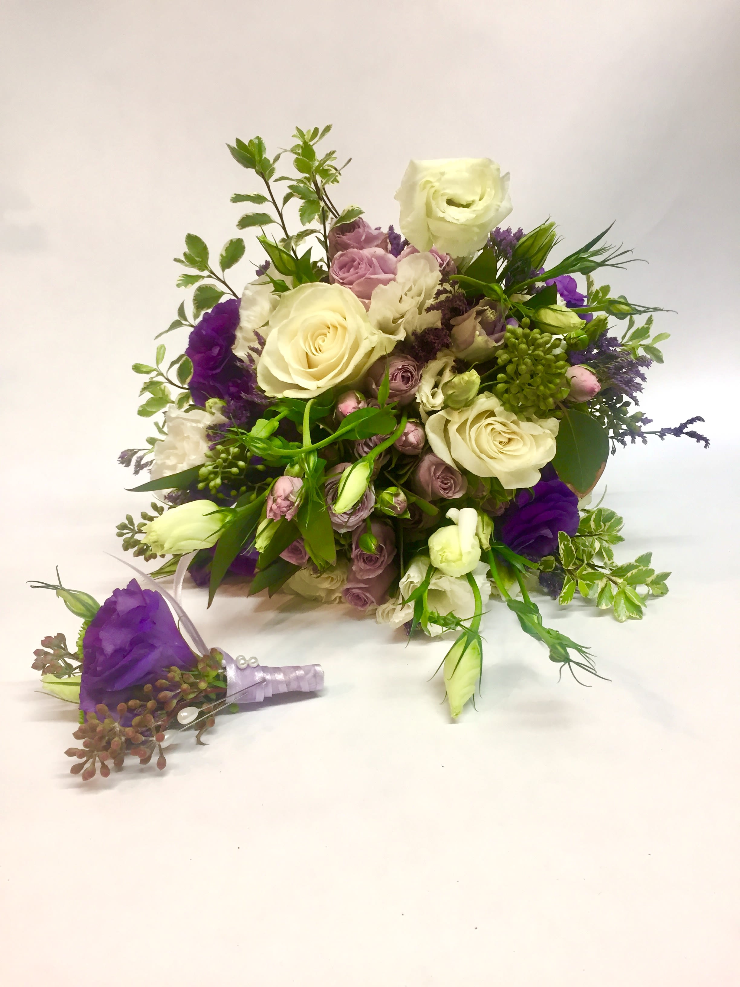 Bouquet of white and purple flowers with a matching boutonniere