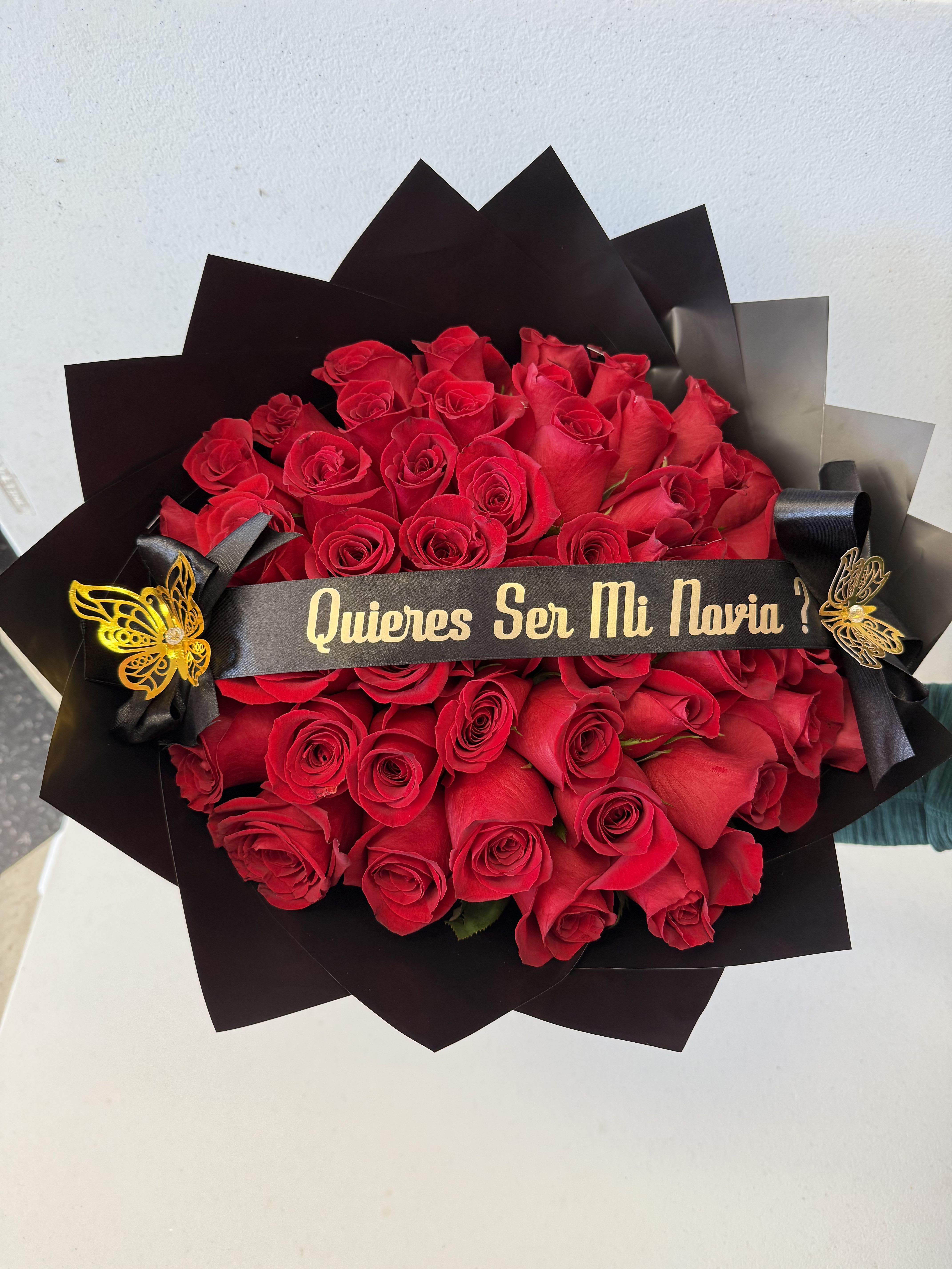 Bouquet of red roses wrapped in black paper with a ribbon