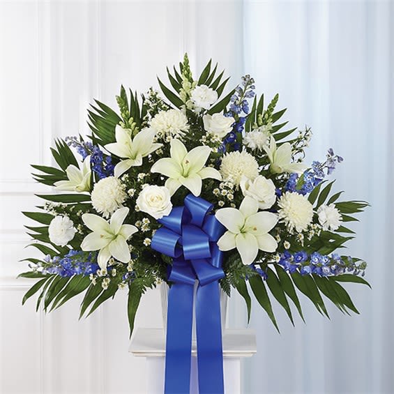 Heartfelt Sympathies Standing Basket- Blue &amp; White - Maybe they loved the color blue…or maybe they enjoyed the calmness of the ocean under a cloudless sky. Our majestic blue and white standing basket arrangement will help honor their memory in a unique and meaningful way. Artistically designed by our expert florists with rich blue and pristine white blooms, this floral tribute is a heartfelt expression of your deepest sympathies. Standing basket arrangement with white roses, Asiatic lilies, football mums, snapdragons, carnations and monte casino; blue delphinium; accented with soft, lush greenery and blue bow   Large measures approximately 36"H x 40"L without stand  Medium measures approximately 34"H x 36"L without stand  Small measures approximately 32"H x 32"L without stand