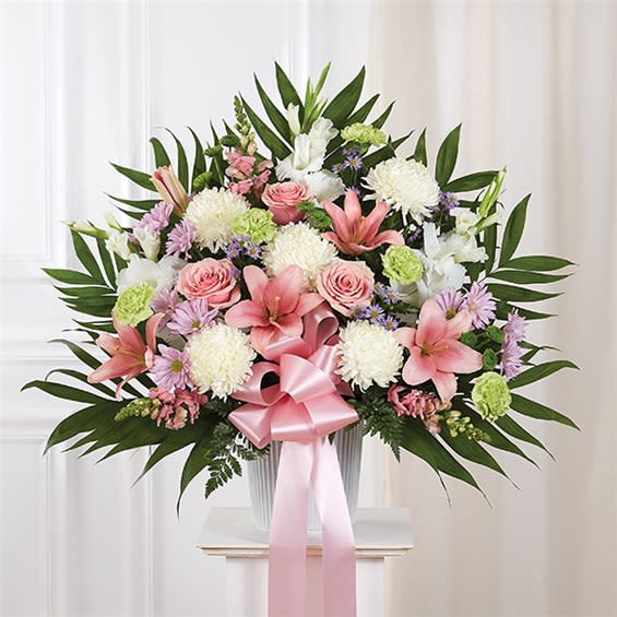 Heartfelt Sympathies Standing Basket- Pastel - When someone we care for deeply passes away, it’s comforting to remember the joy and happiness they brought to those around them. Filled with lush blooms in soft, light pastel shades, our traditional standing basket arrangement is handcrafted by expert florists, creating a touching tribute to celebrate the life of a loved one who will never be forgotten. •Standing basket arrangement with pink roses, Asiatic lilies and snapdragons; white gladiola and football mums; lime green carnations; green button poms; accented with soft, lush greenery and pink bow  •Large measures approximately 36"H x 40"L without stand •Medium measures approximately 34"H x 36"L without stand •Small measures approximately 32"H x 32"L without stand