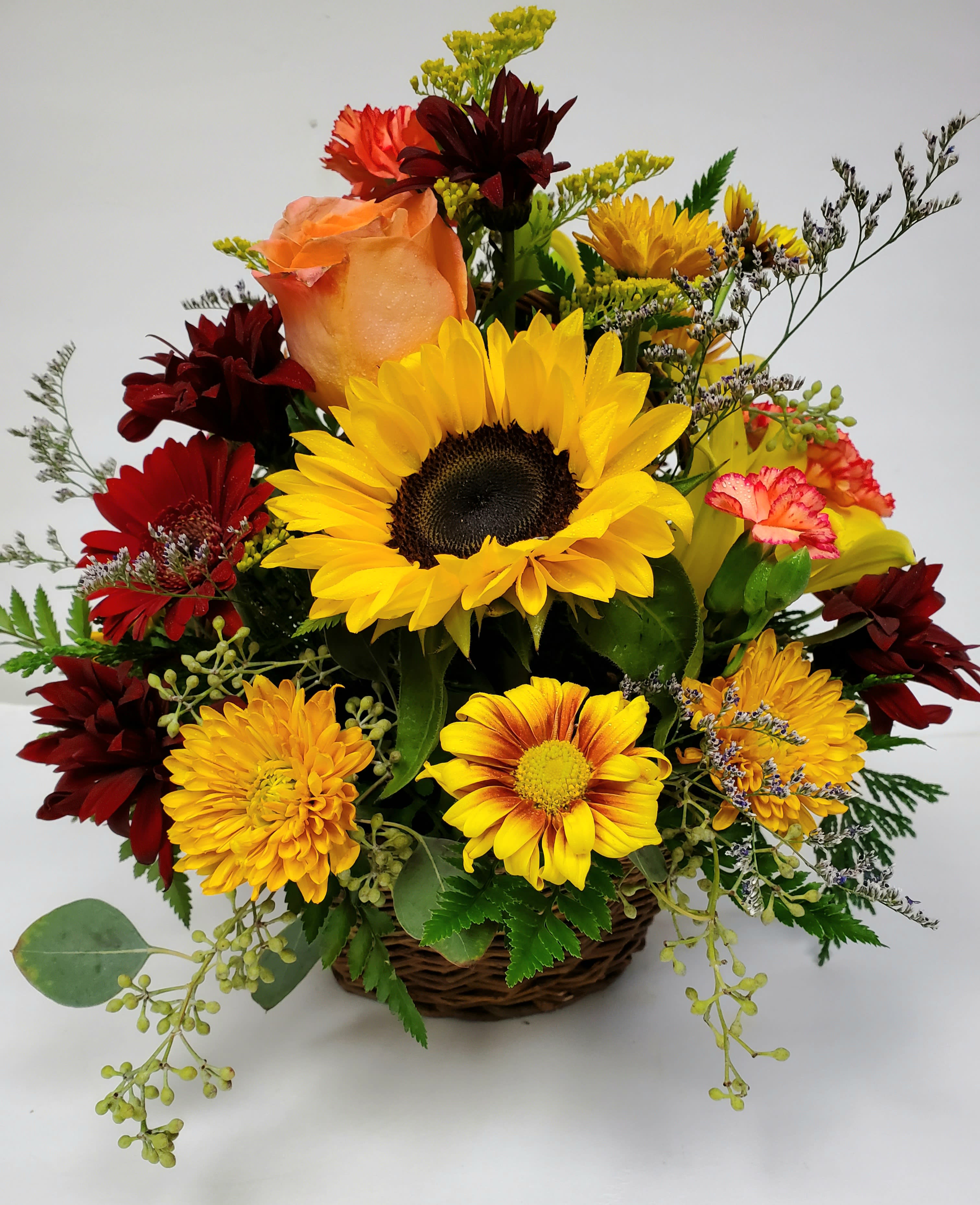 Autumn  - Fall  flowers in a basket.Perfect as an all occasion gift during the fall months. This bright and cheerful basket  will put smiles on faces!