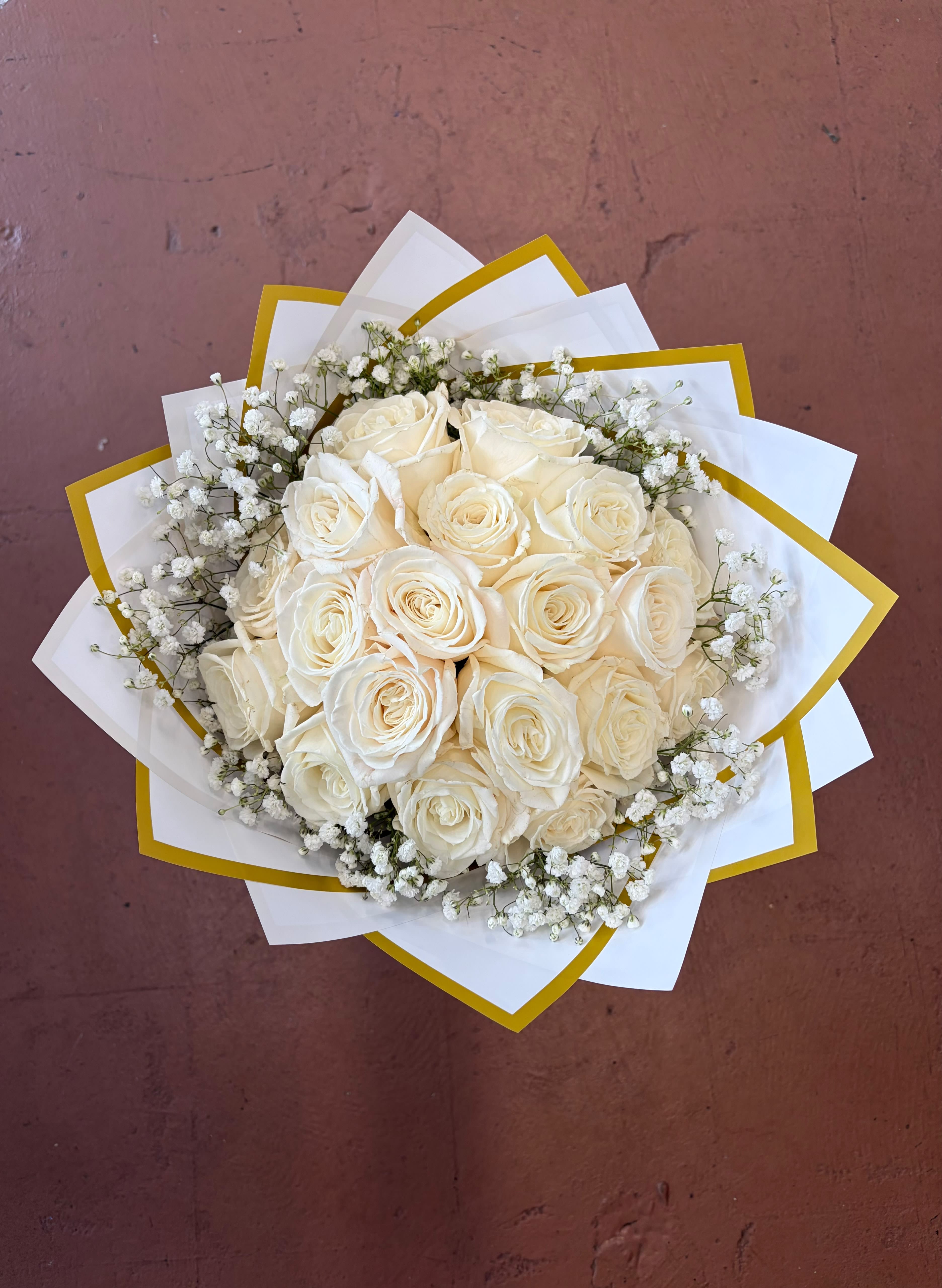 Grand Pearl Bouquet - Creamy white roses form a lush, rounded wedding bouquet that reads soft, romantic, and quietly elegant - perfect as an anniversary roses arrangement, bridal bouquet, or a sympathy floral tribute. The dense cluster of cream-white blooms creates an immediate sense of warmth and grace, so the person you're thinking of will feel comforted and cherished the moment they see it.