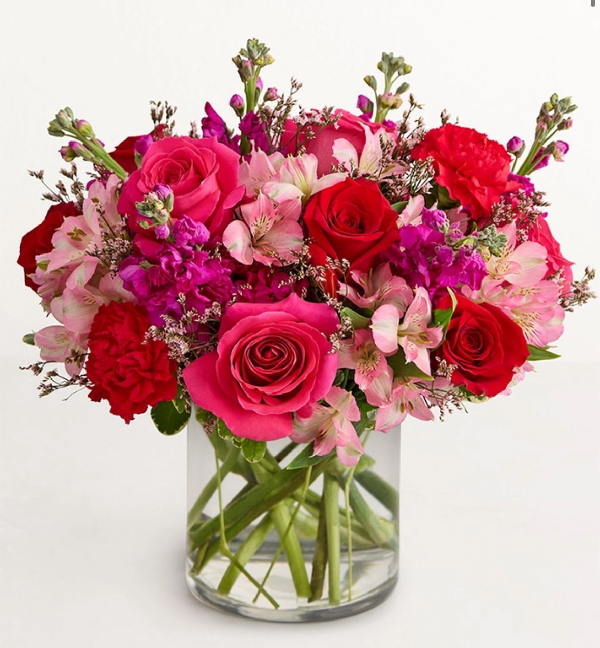 Bouquet of pink and red roses with pale pink alstroemeria in a clear glass vase