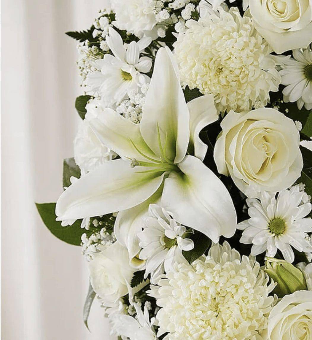 White floral bouquet with lilies, roses, and daisies