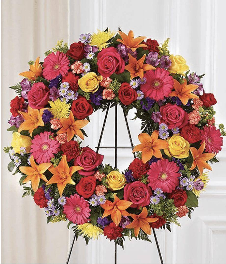 Colorful floral wreath on a black easel stand