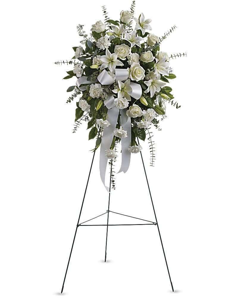 White funeral spray on a standing easel with ribbon